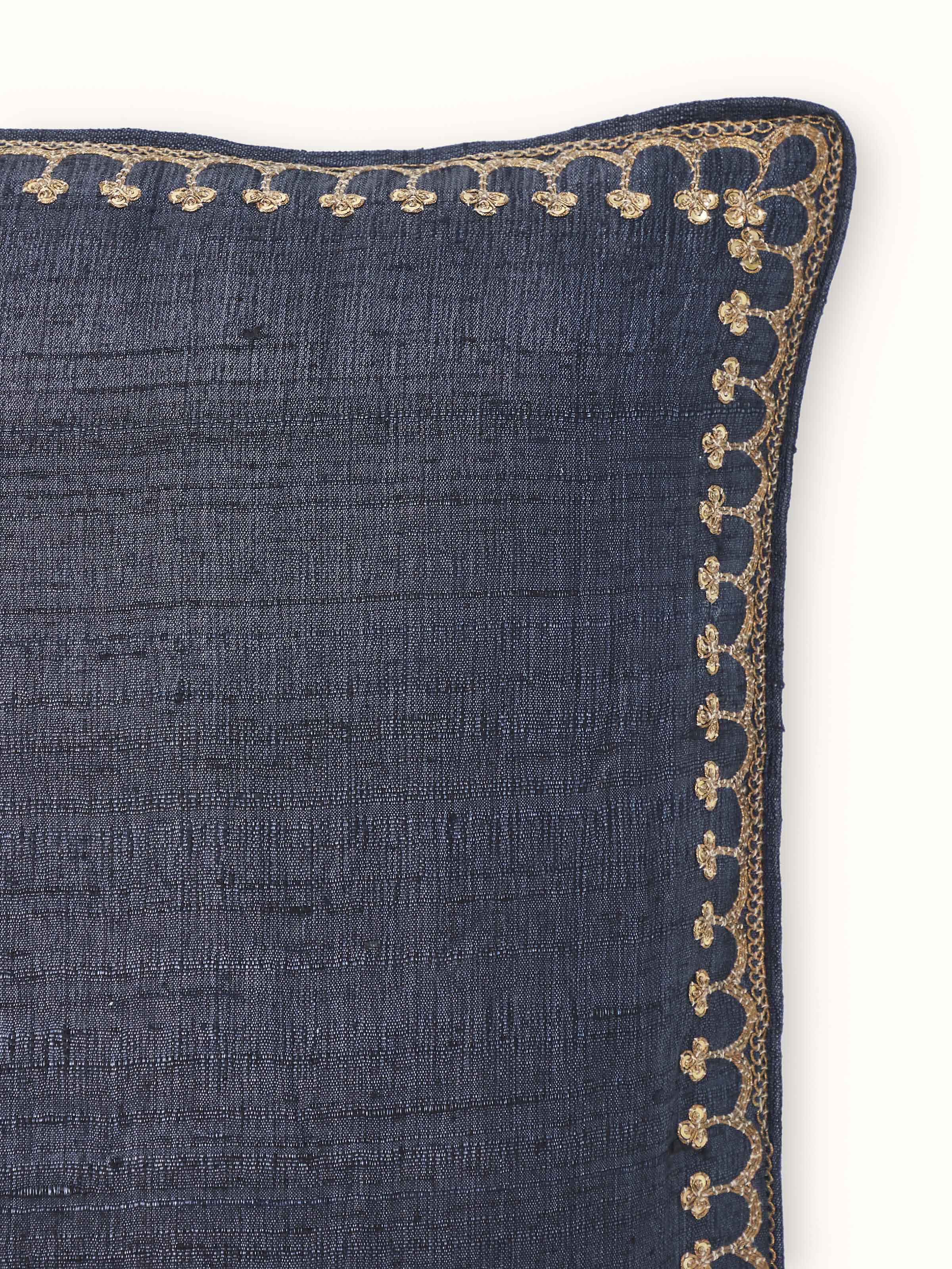 Full view of Alankar dark blue buti silk zardozi embroidered cushion cover displayed on a sofa.