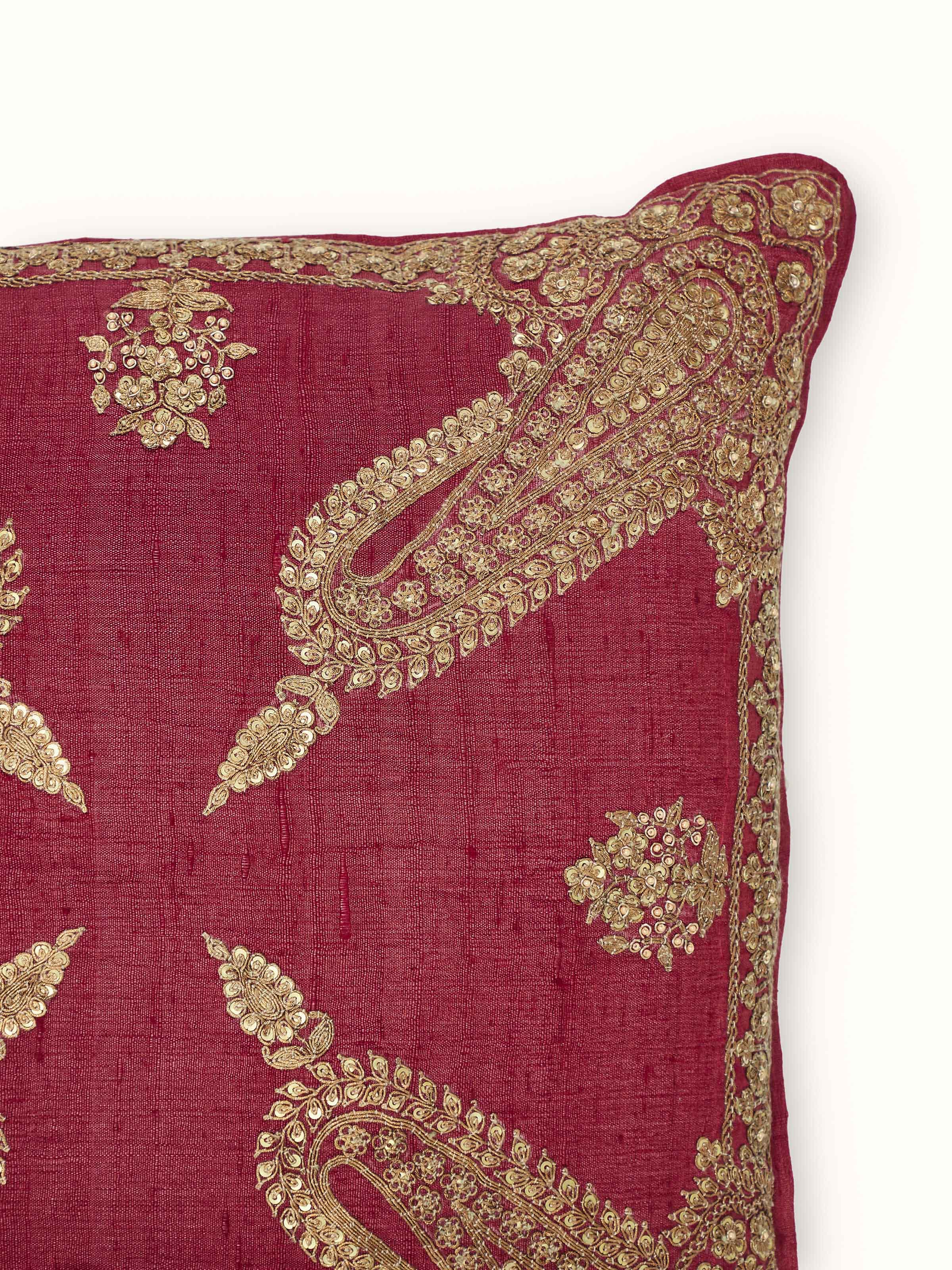 Perspective view of Alankar maroon koniya paisley silk zardozi embroidered cushion cover highlighting the paisley design and embroidery details.