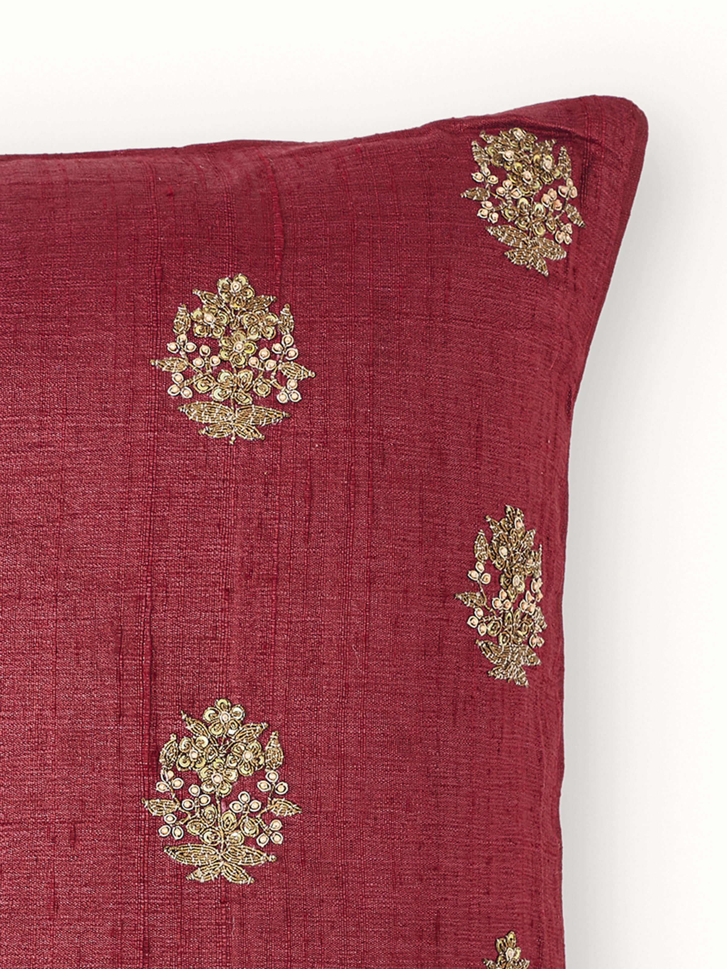 Side view of Alankar Maroon Buti Silk Zardozi Embroidered Cushion Cover emphasizing the cushion’s shape and embroidery work.