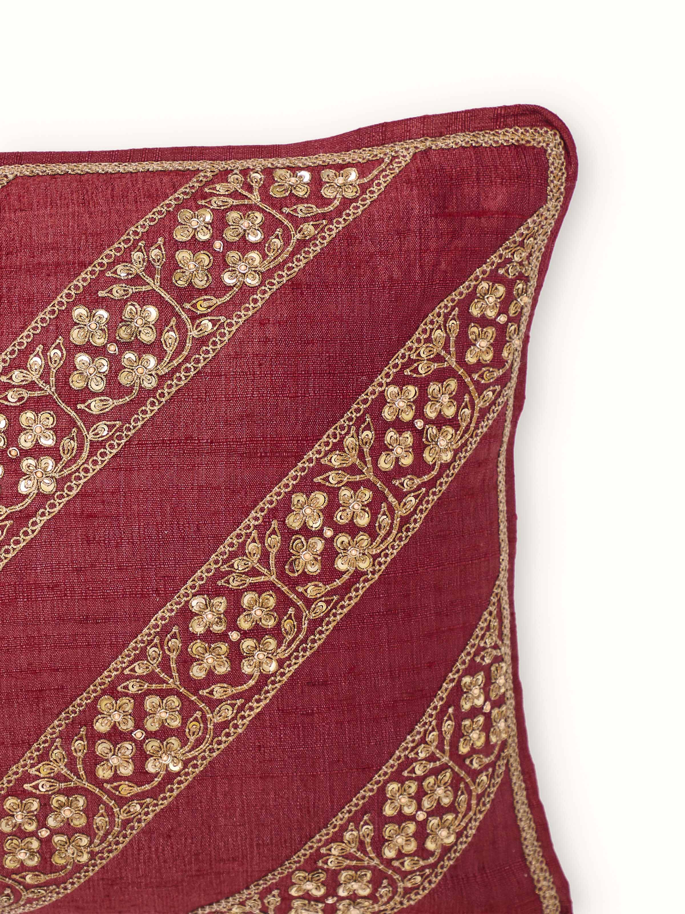 Angled view of Alankar Maroon Diagonal Stripe Silk Zardozi Embroidered Cushion Cover featuring diagonal stripe pattern