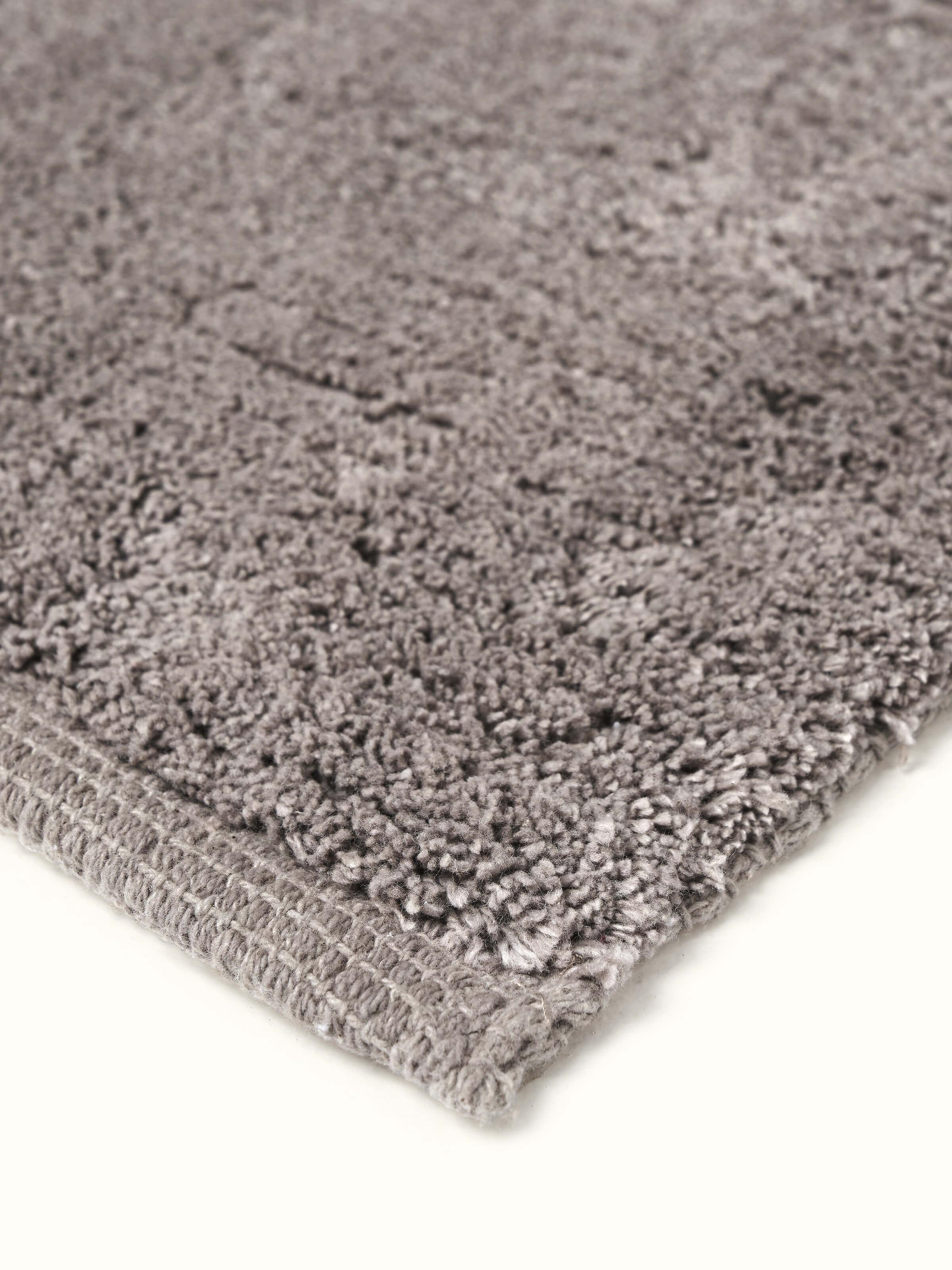 Side view of Karya solid brown cotton bath mat showing its edge and overall design