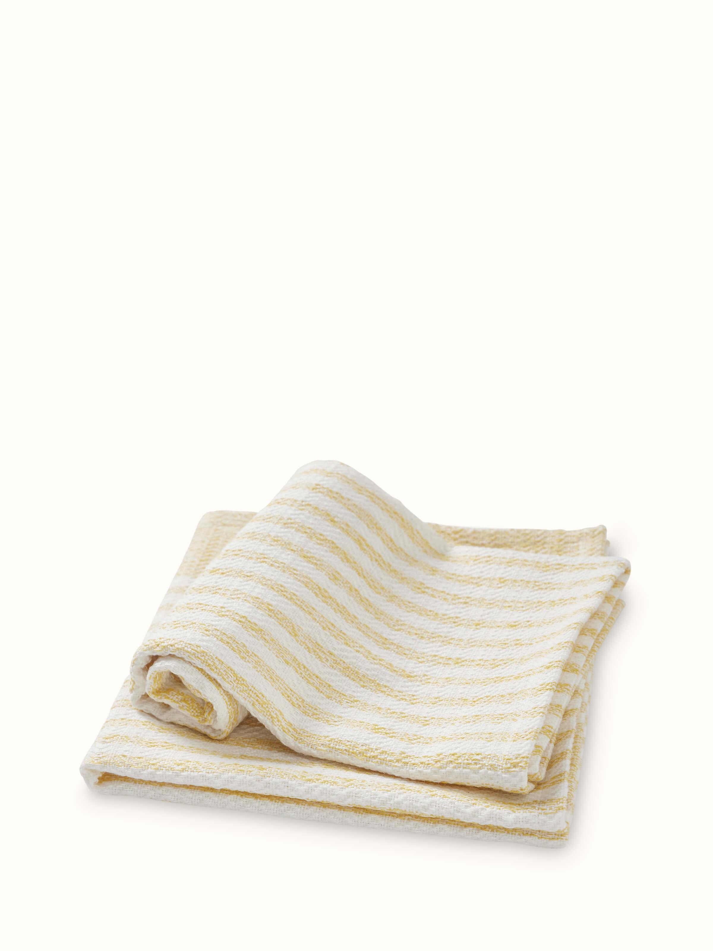 Angled view of Vayana Stripe Yellow Cotton Hand Towels (2 pcs), showing the towels in use and their striped design.