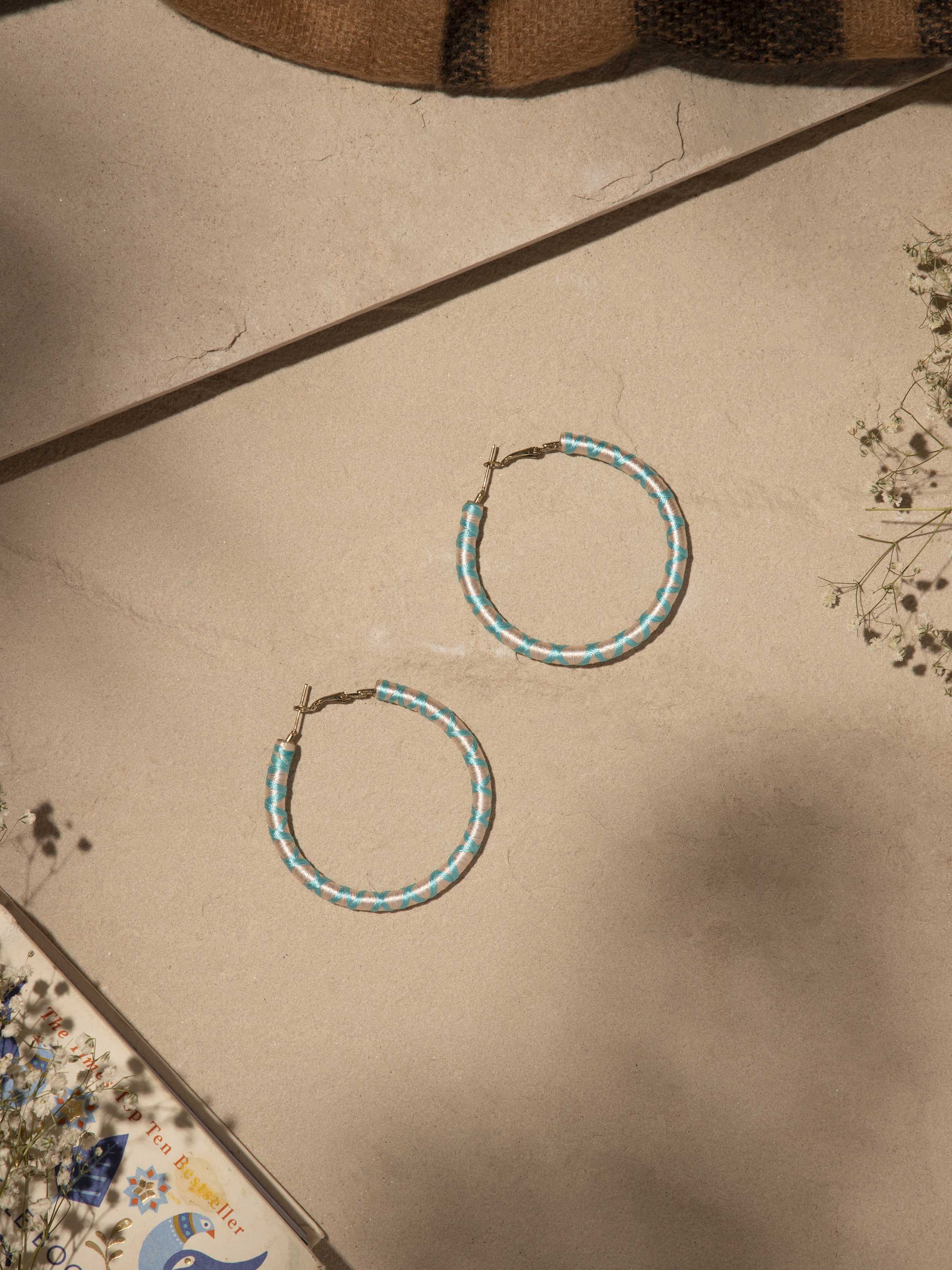 Close-up view of handcrafted hoop earrings highlighting the texture and intricate detailing.