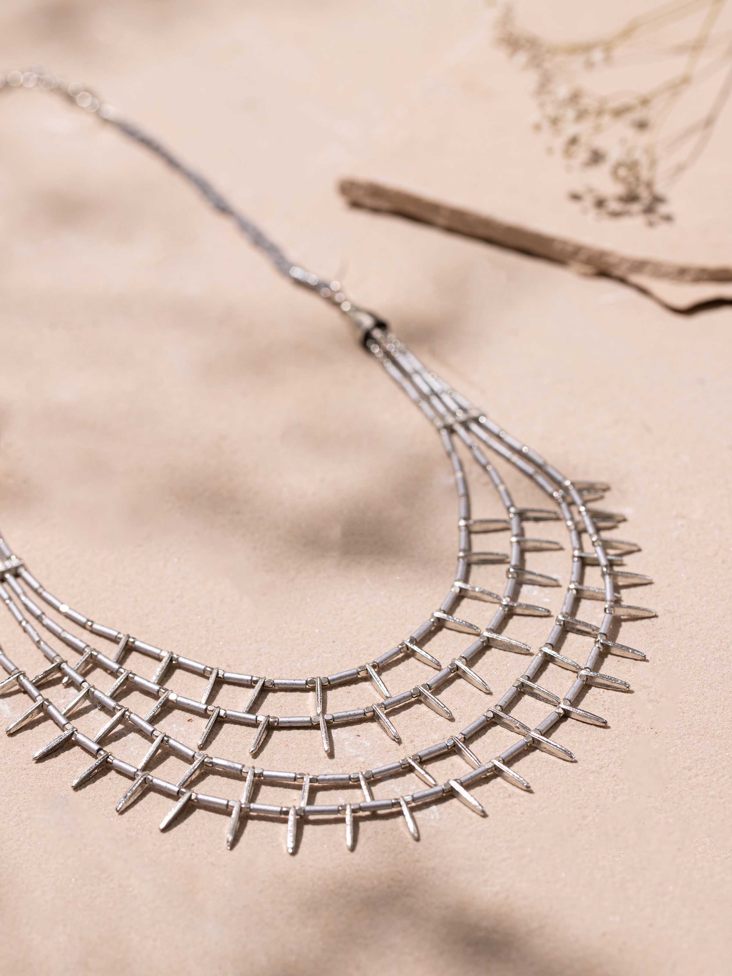 Detailed close-up of handcrafted collar necklace highlighting the craftsmanship and texture.