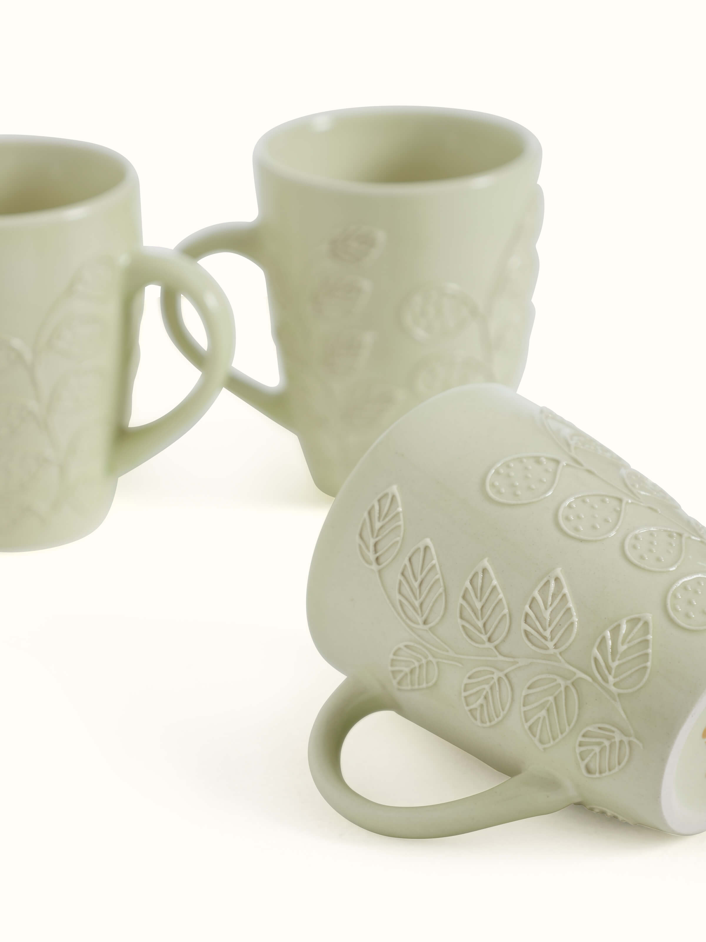 Detailed view of Khurja pottery ceramic simple coffee mugs in white, focusing on the fine glaze and even color