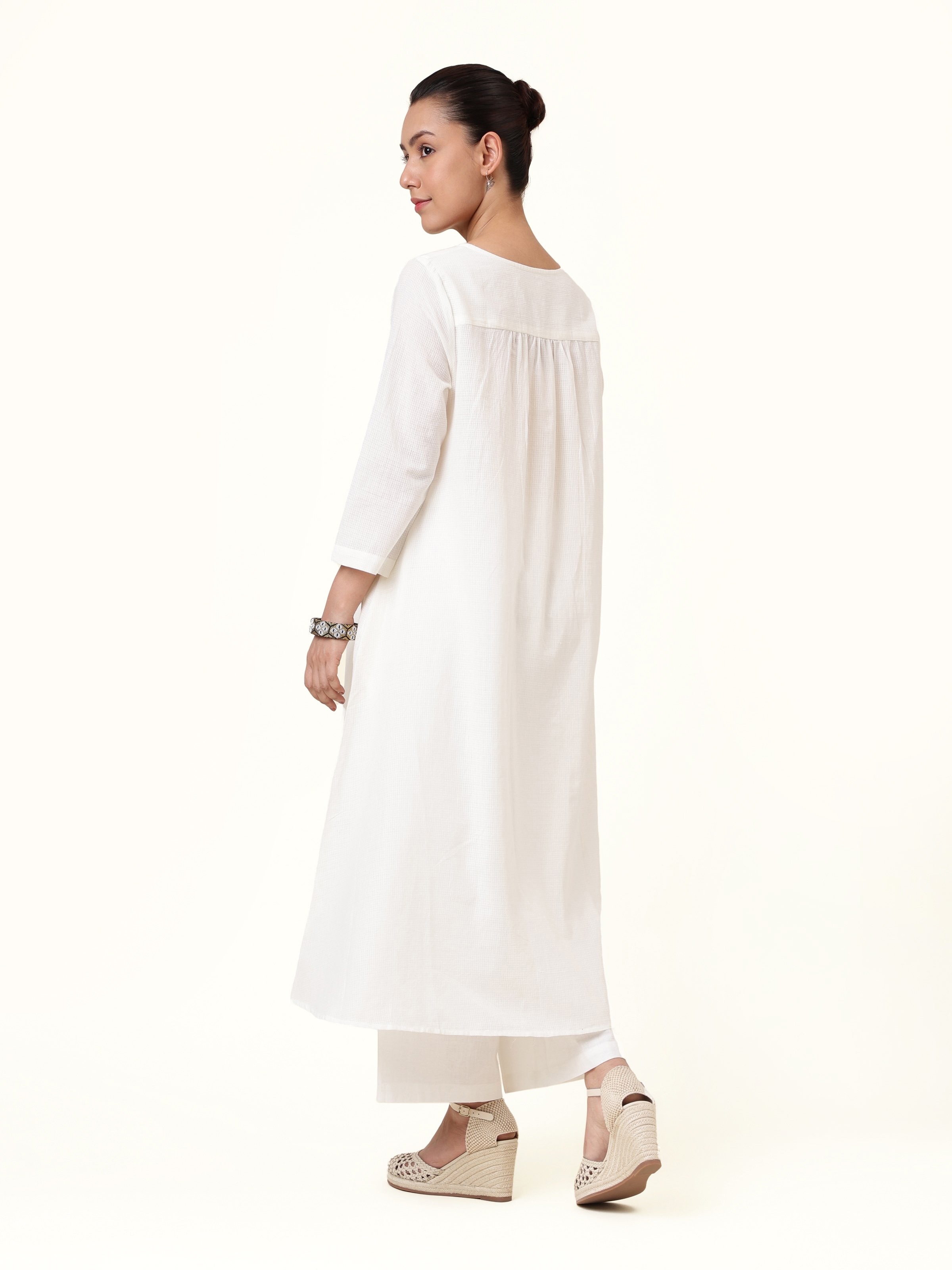 Back view showing extended length and relaxed fit of hand-spun cotton kurta.