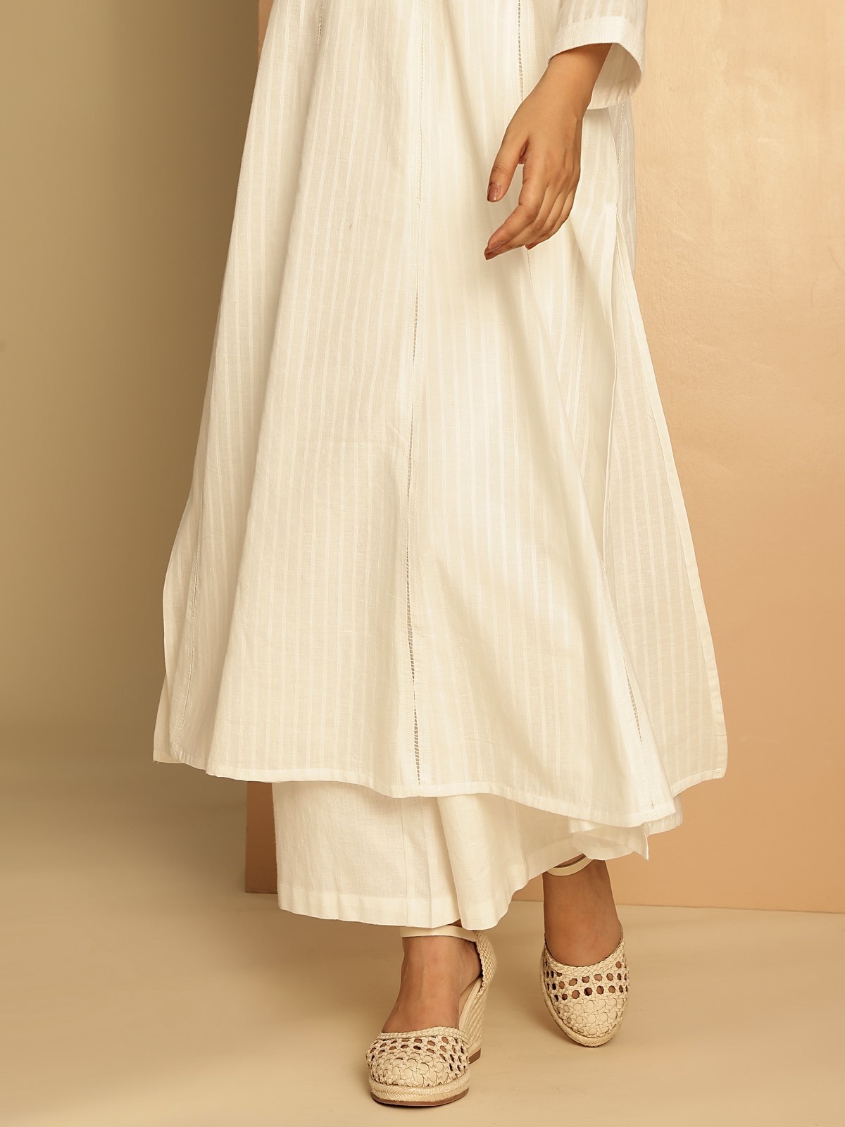 Detailed side view of white cotton hand-spun long Anarkali kurta with soft folds and natural drape.