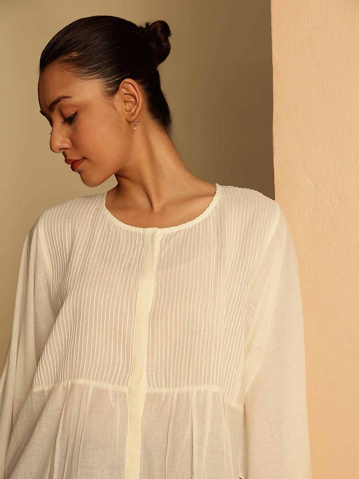 Detail view of white cotton hand-spun top showing hand-spun cotton texture