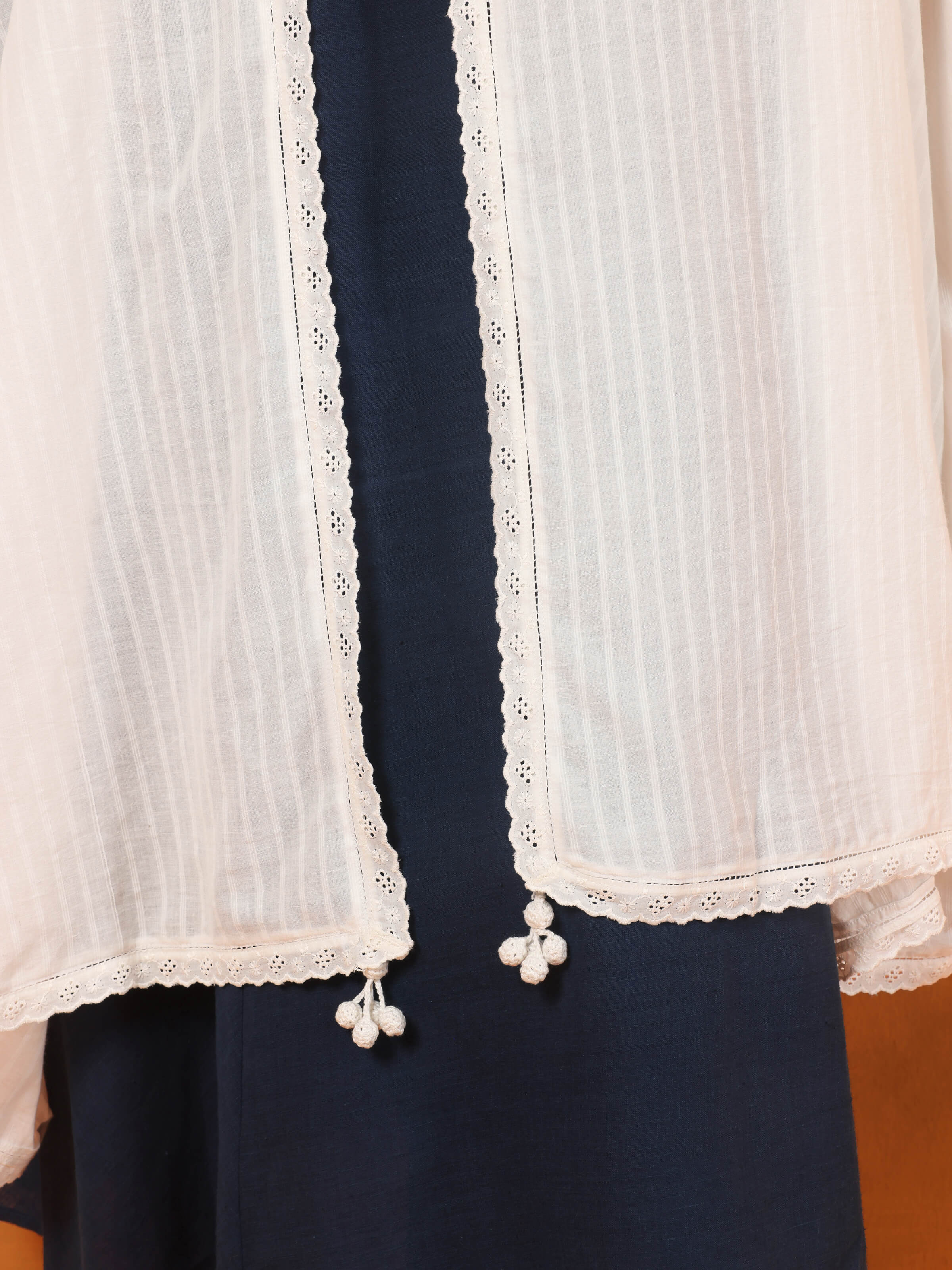 Close-up of white hand-spun cotton dupatta draped on shoulder, highlighting texture and translucence.