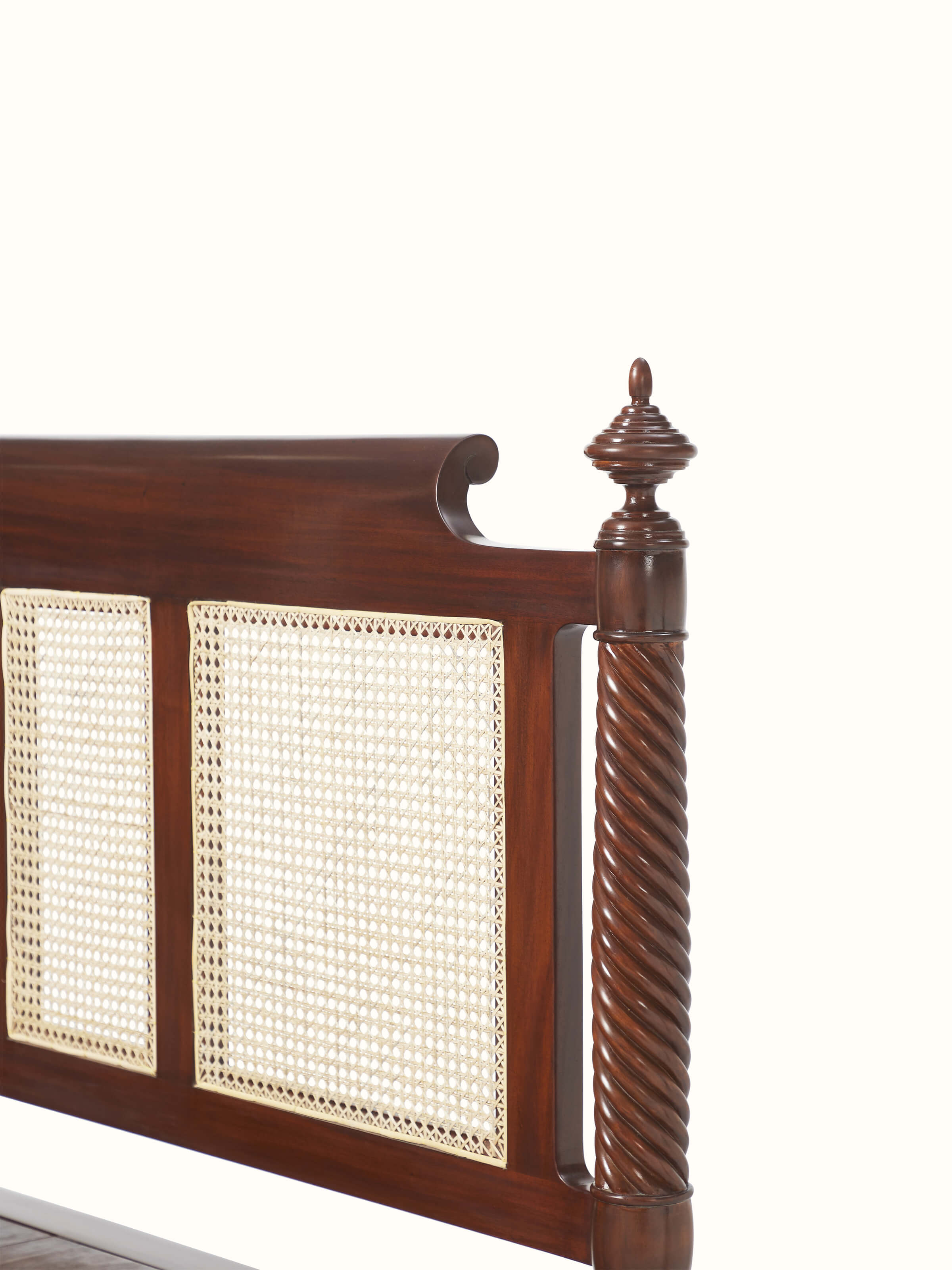 Detailed shot of the cane work and carved wood on the queen size bed, emphasizing the intricate design and texture.