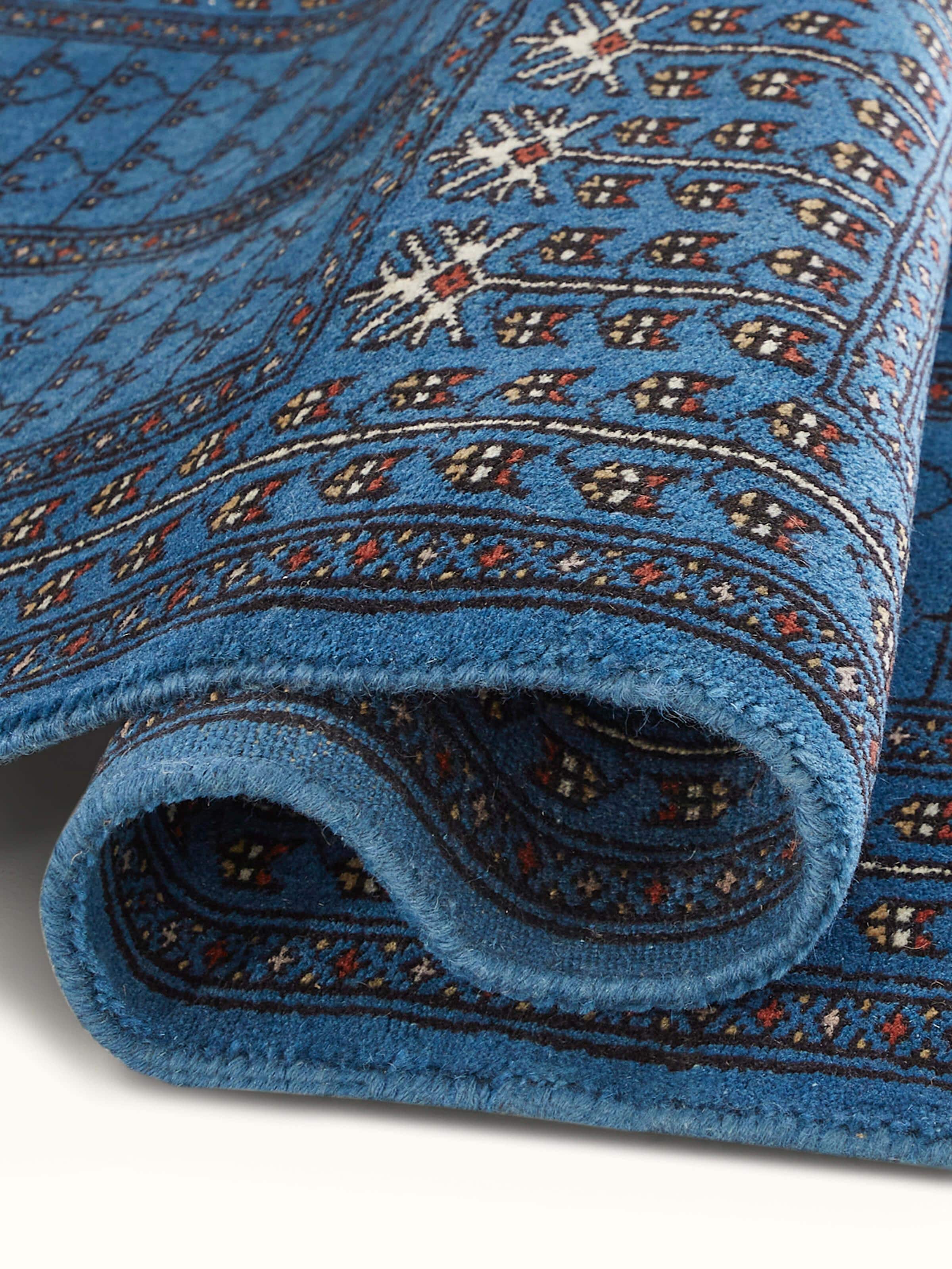 Close-up of the Amritsari parda blue Gwalior wool hand-knotted runner, focusing on the edge detailing and pattern.