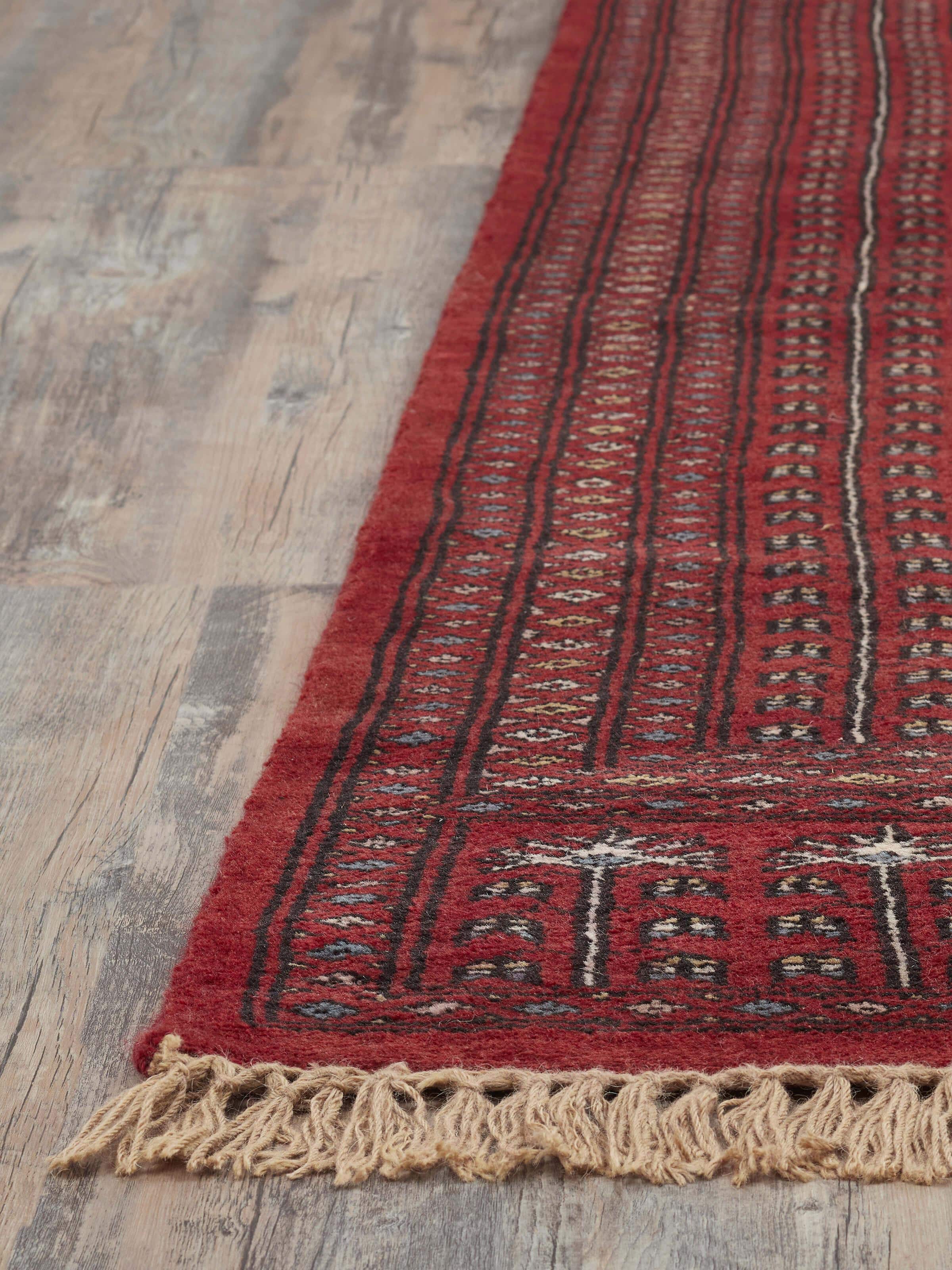 Overhead view of Amritsari Parda red Gwalior wool rug showing the full design and color variations