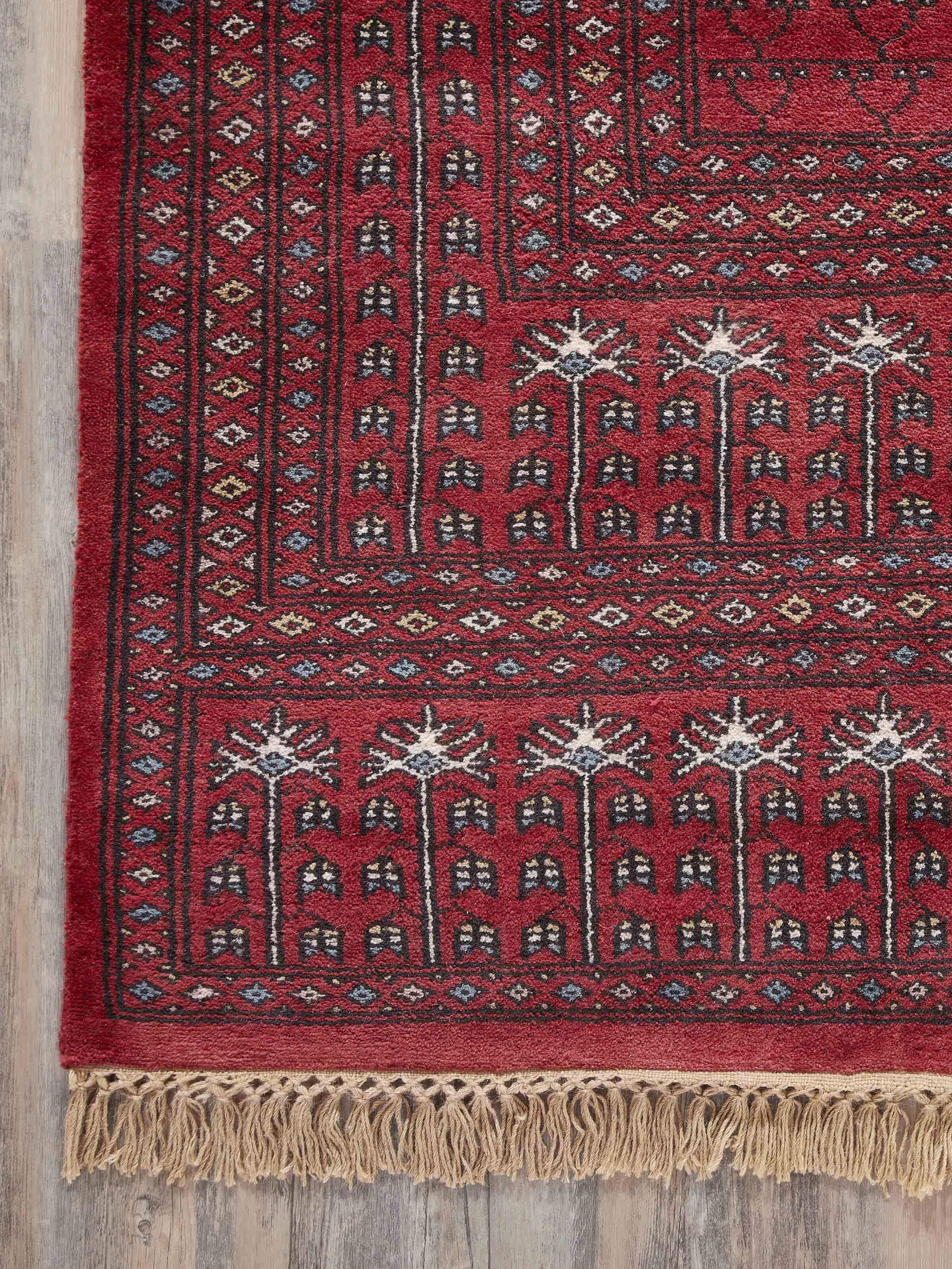 Side view of Amritsari Parda red Gwalior wool rug displaying the thickness and edge details