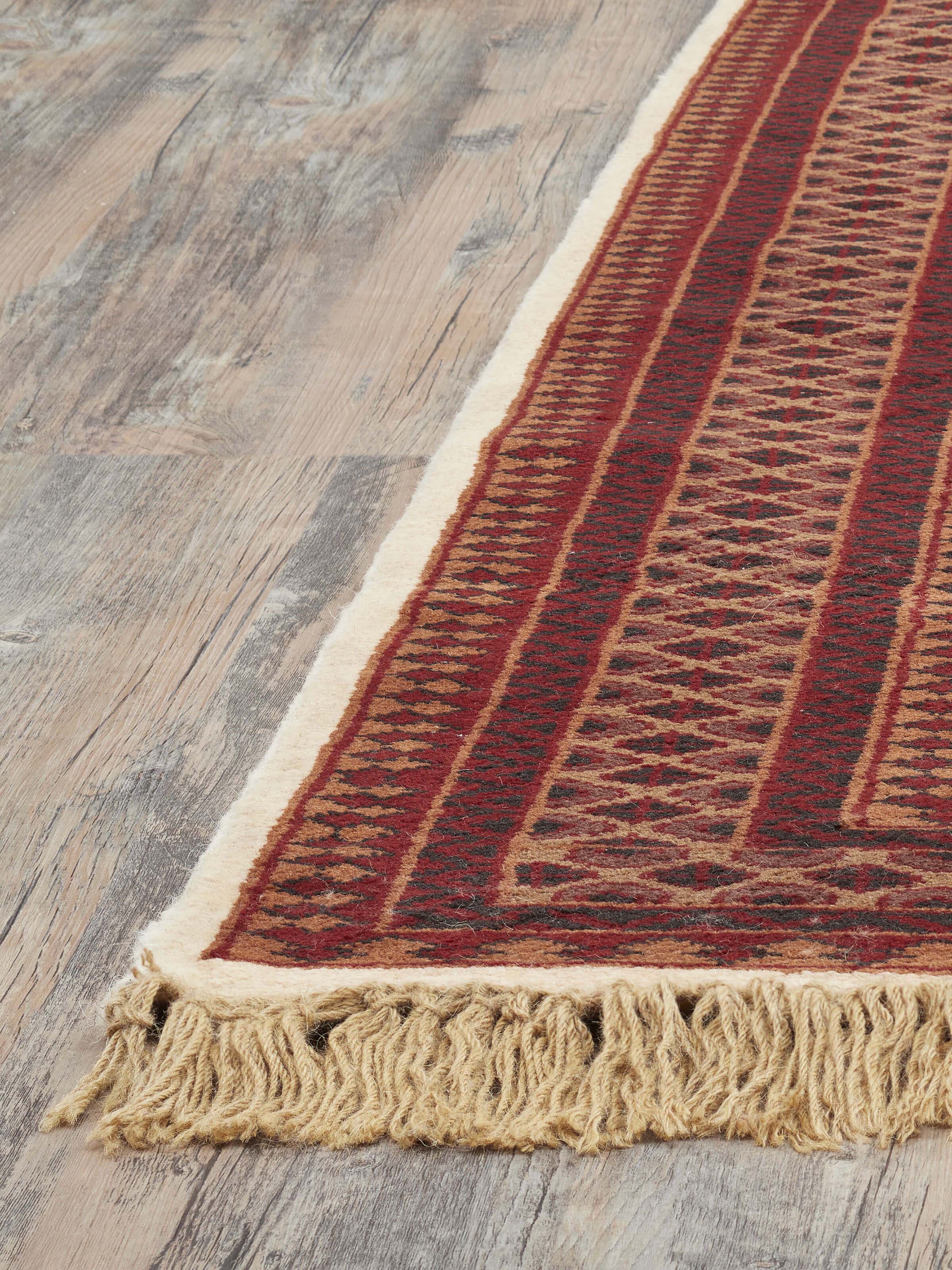 Detailed view of Traditional Lichi Ivory Rust Gwalior wool hand-knotted rug, focusing on the color gradient and design intricacies.