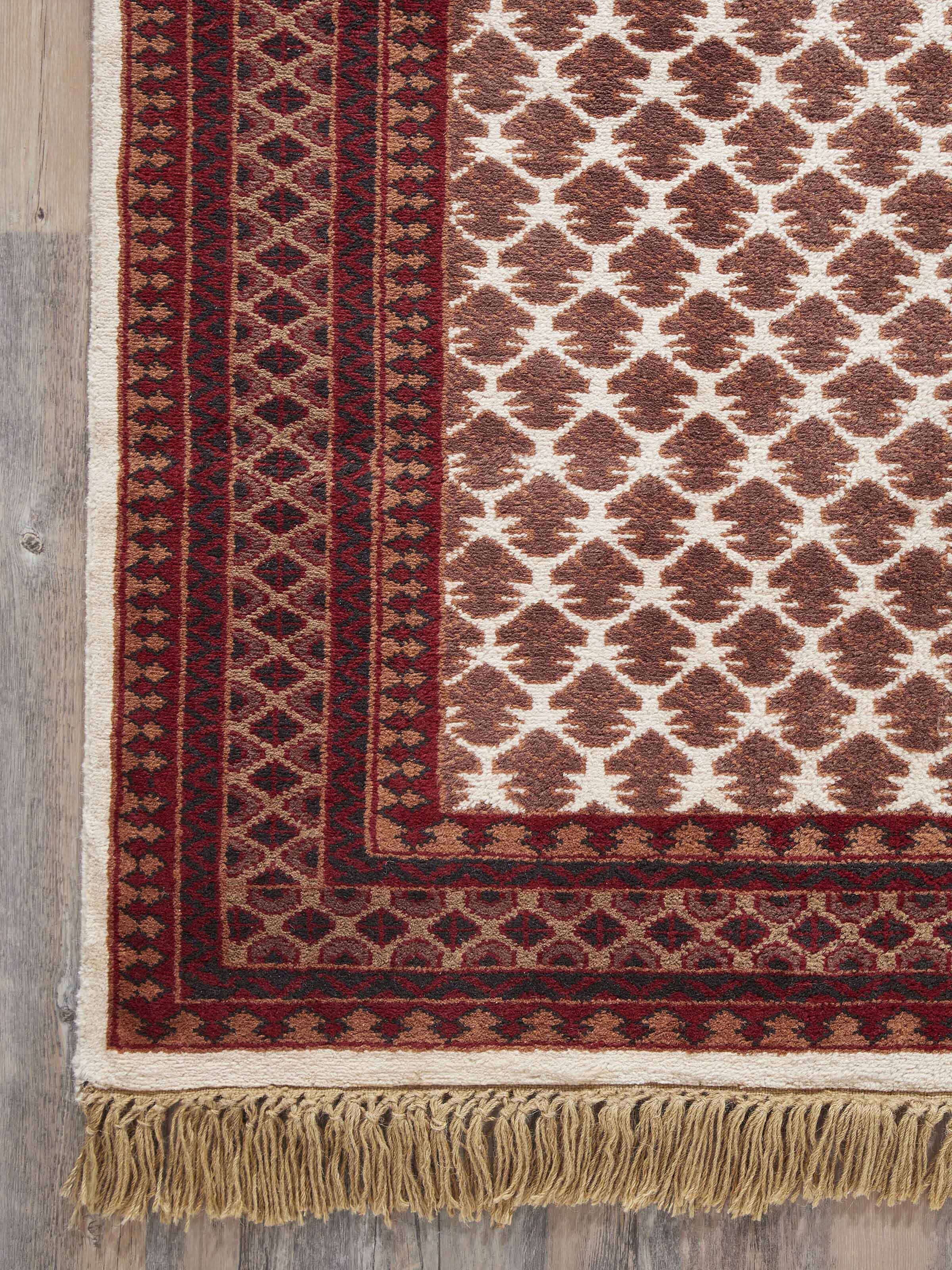 Traditional Lichi Ivory Rust Gwalior wool hand-knotted rug displayed on the floor, emphasizing its design and size in a room setting.
