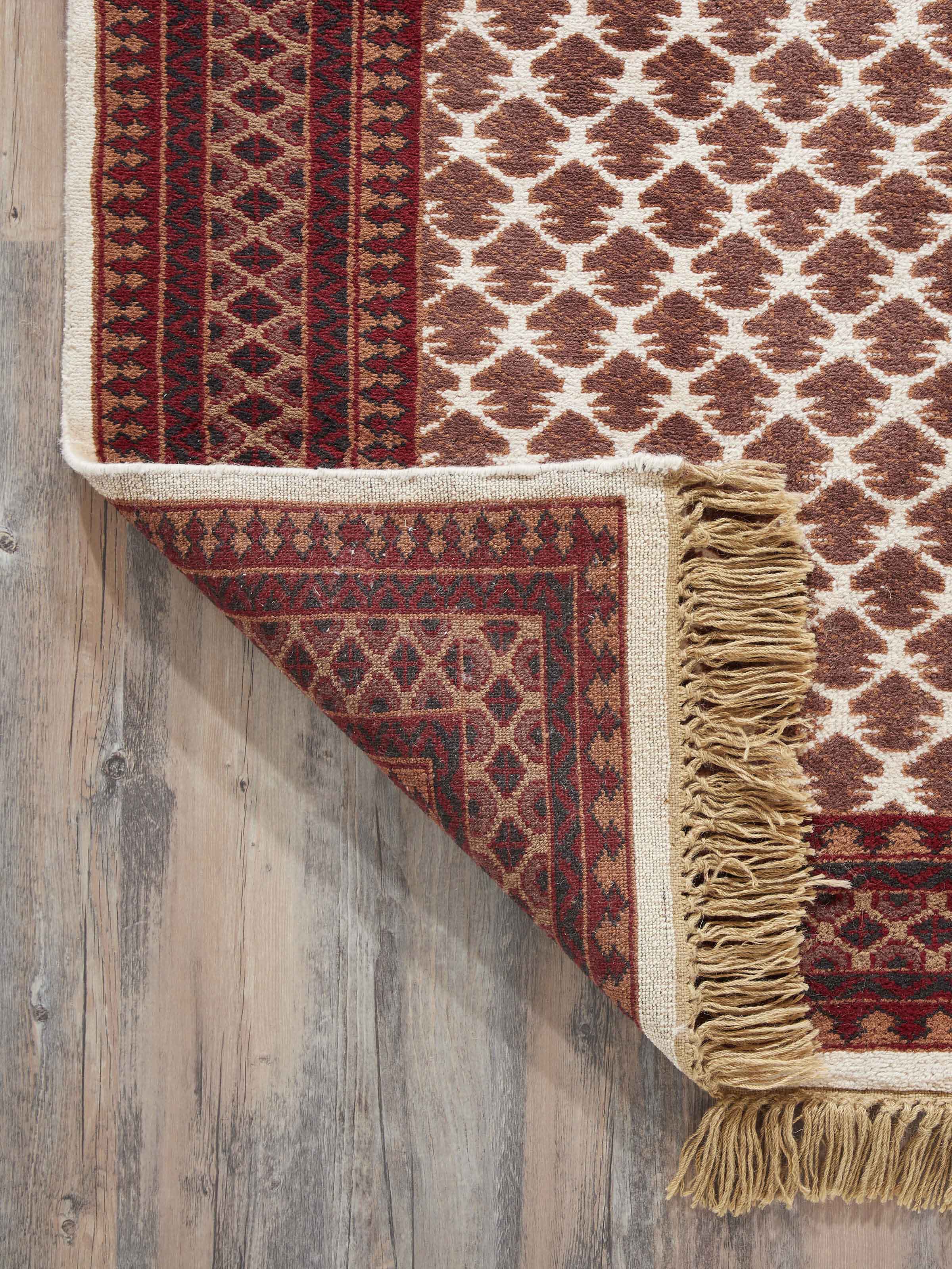 Close-up of Traditional Lichi Ivory Rust Gwalior wool hand-knotted rug, highlighting the wool texture and intricate design details.