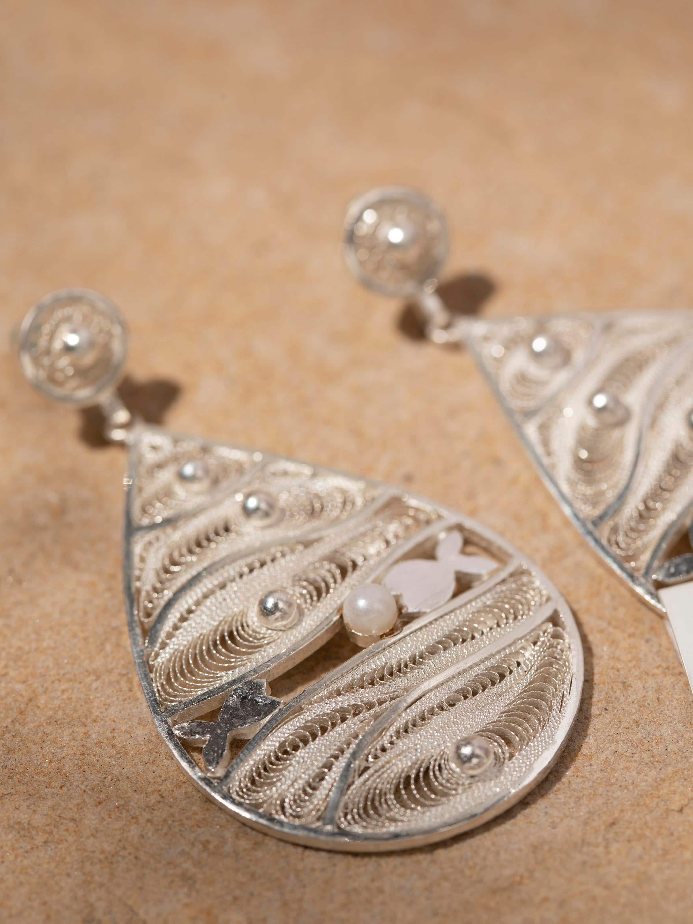 Detailed view of Silver Filigree Drop Earrings from a distance showcasing their overall design.
