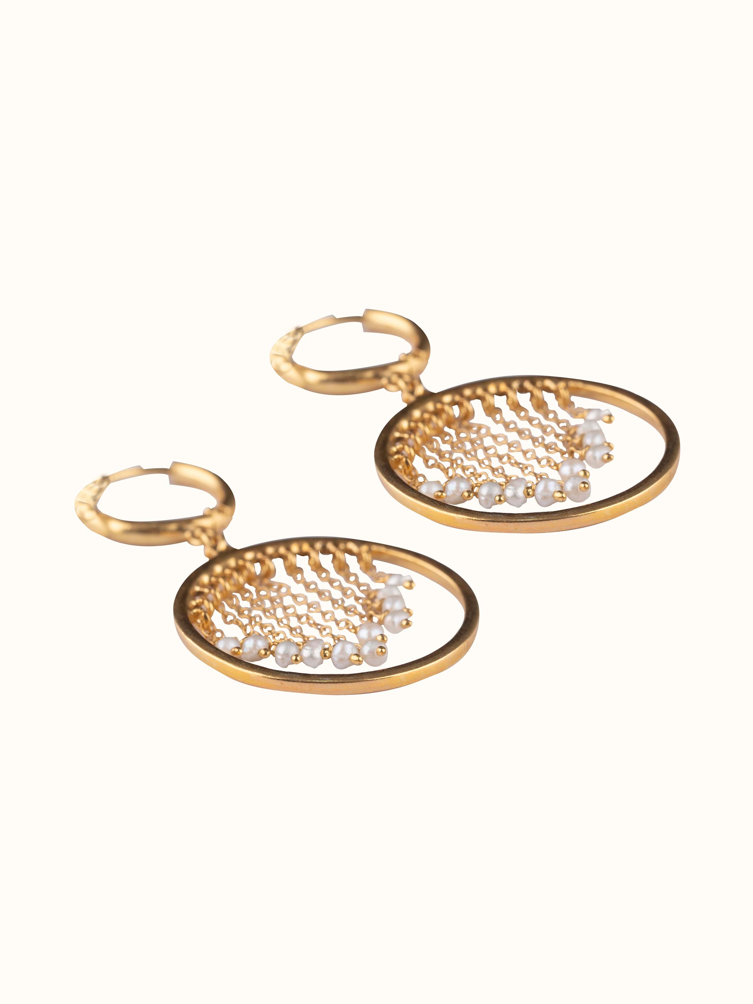 Overhead view of silver smithing drop earrings displaying their fine contours and modern aesthetic