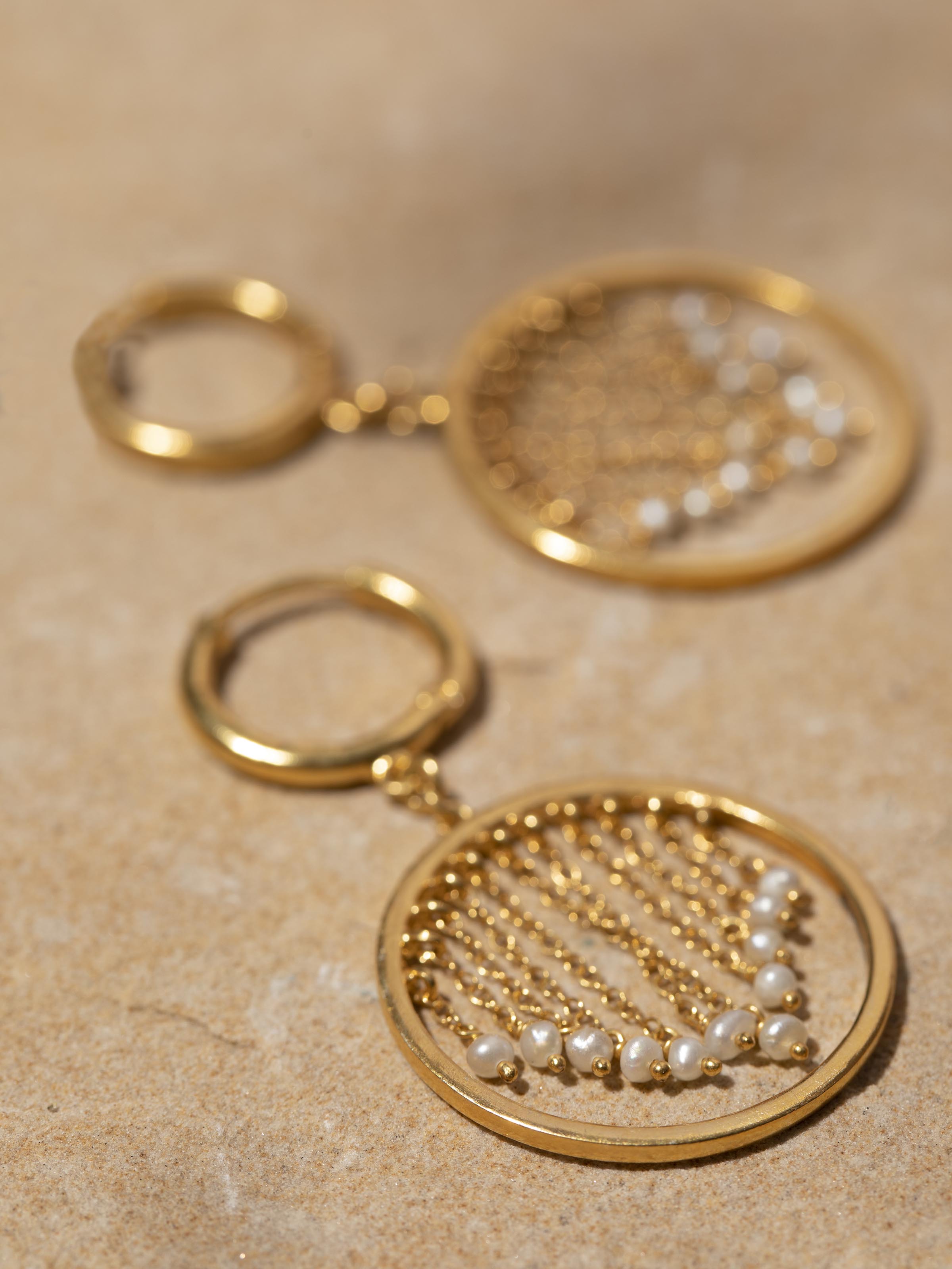 Detailed view of silver smithing drop earrings focusing on intricate metalwork and refined finish