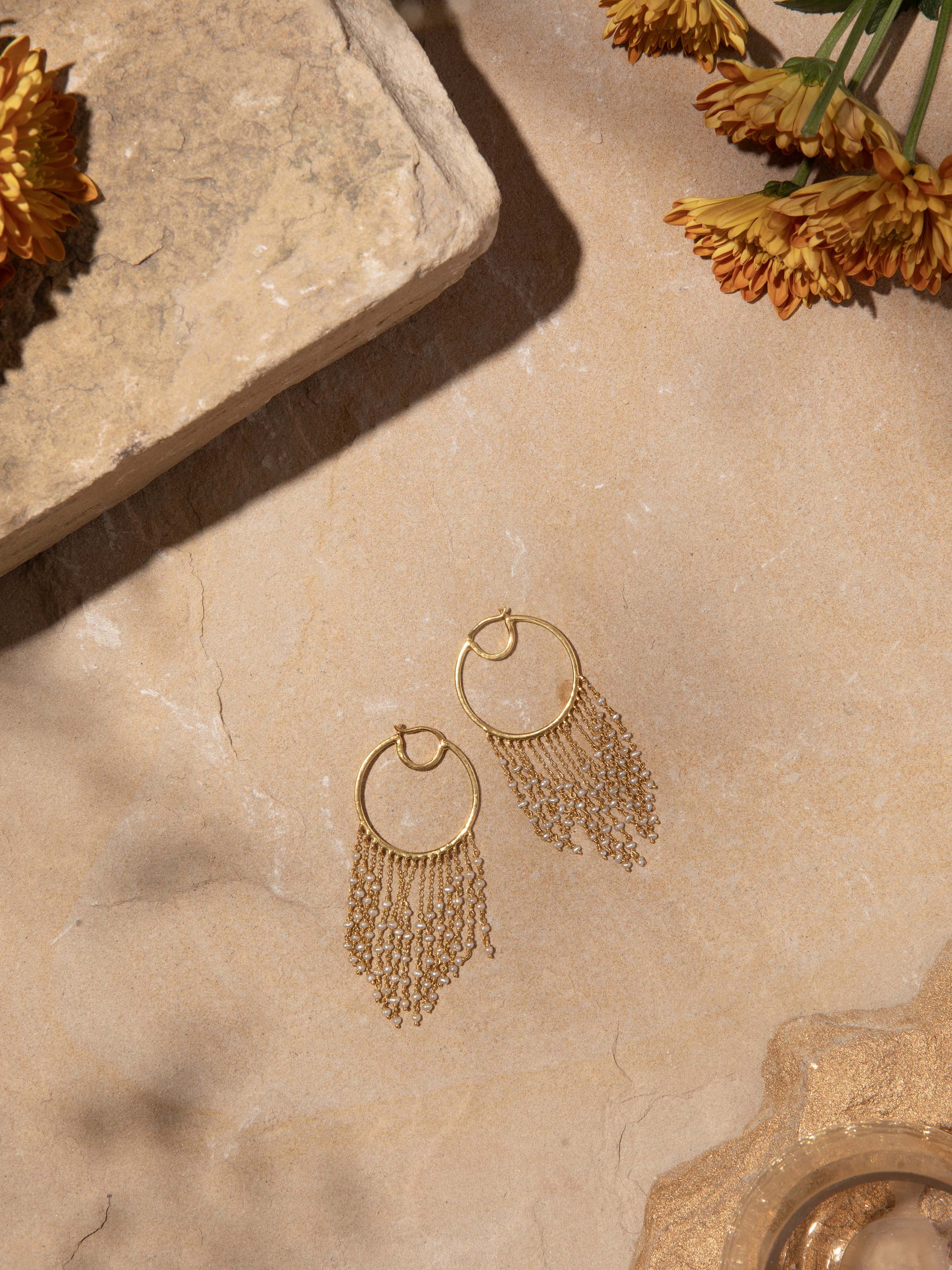 Angled view of silver smithing hoops emphasizing their detailed design and shiny finish