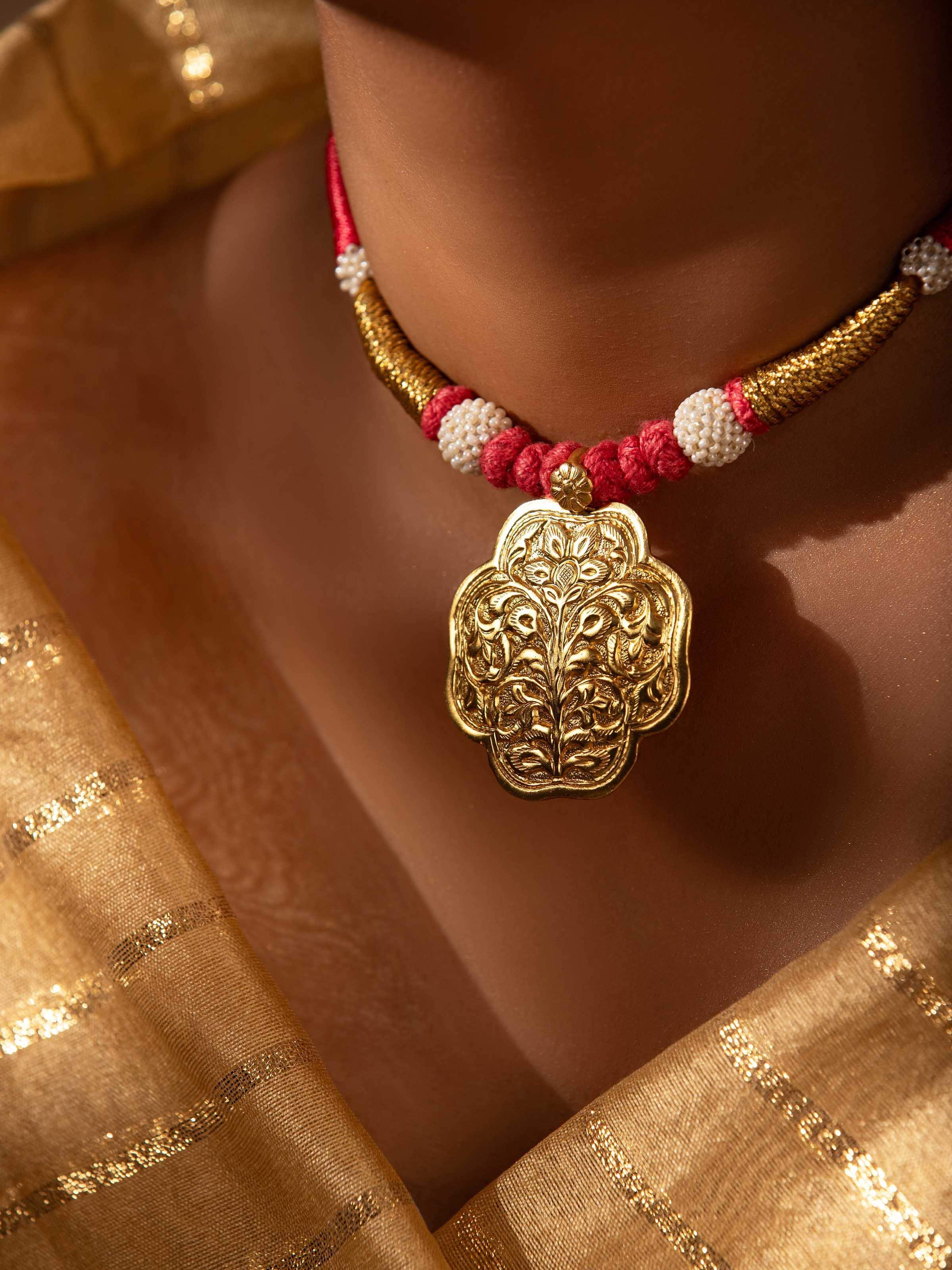 Close-up of detailed silver work and artistic motifs on the collar necklace