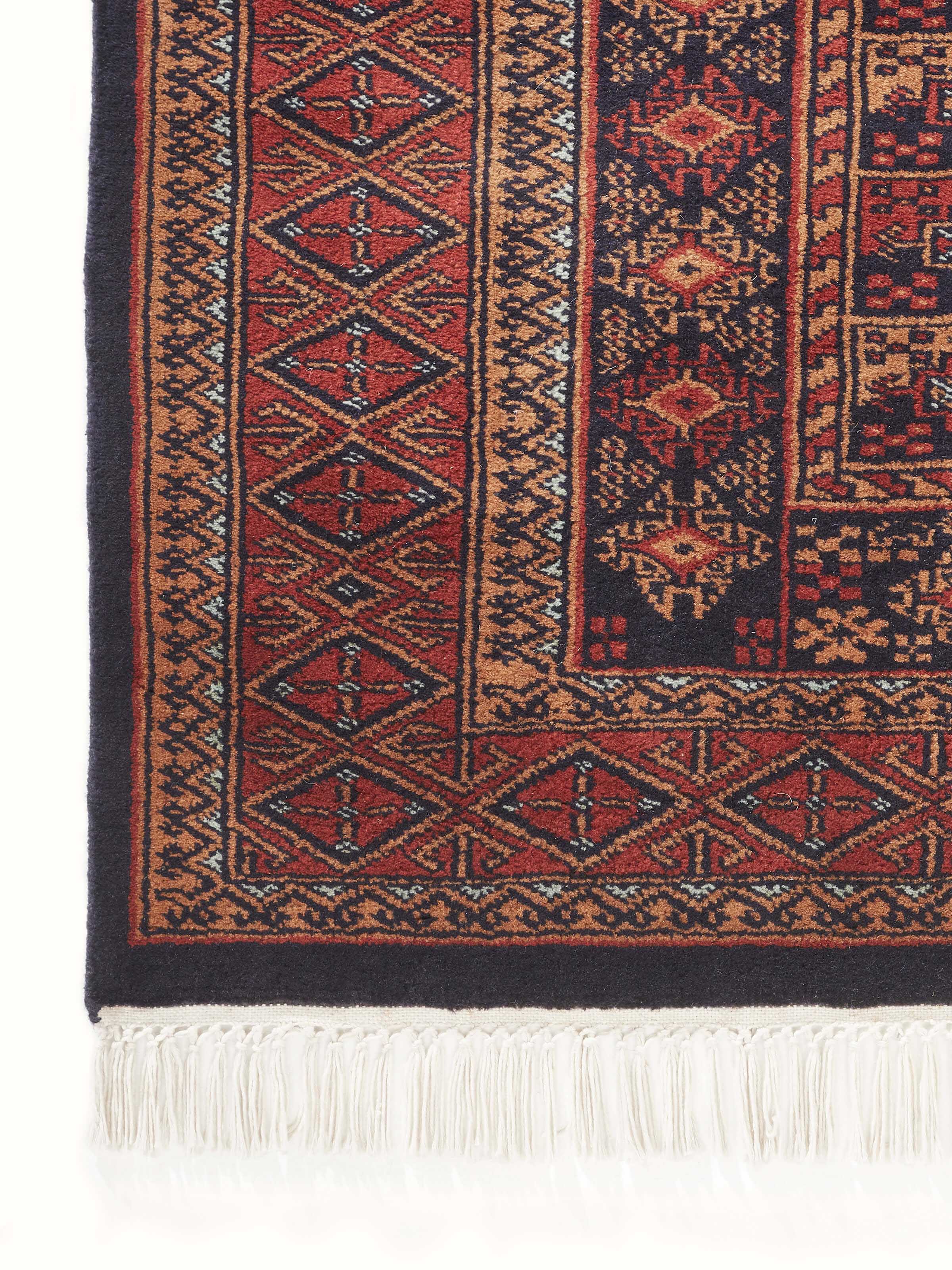 Angled view of Traditional Bukhara Red Gwalior Wool Hand-Knotted Rug displaying the rich red hues and traditional pattern details.