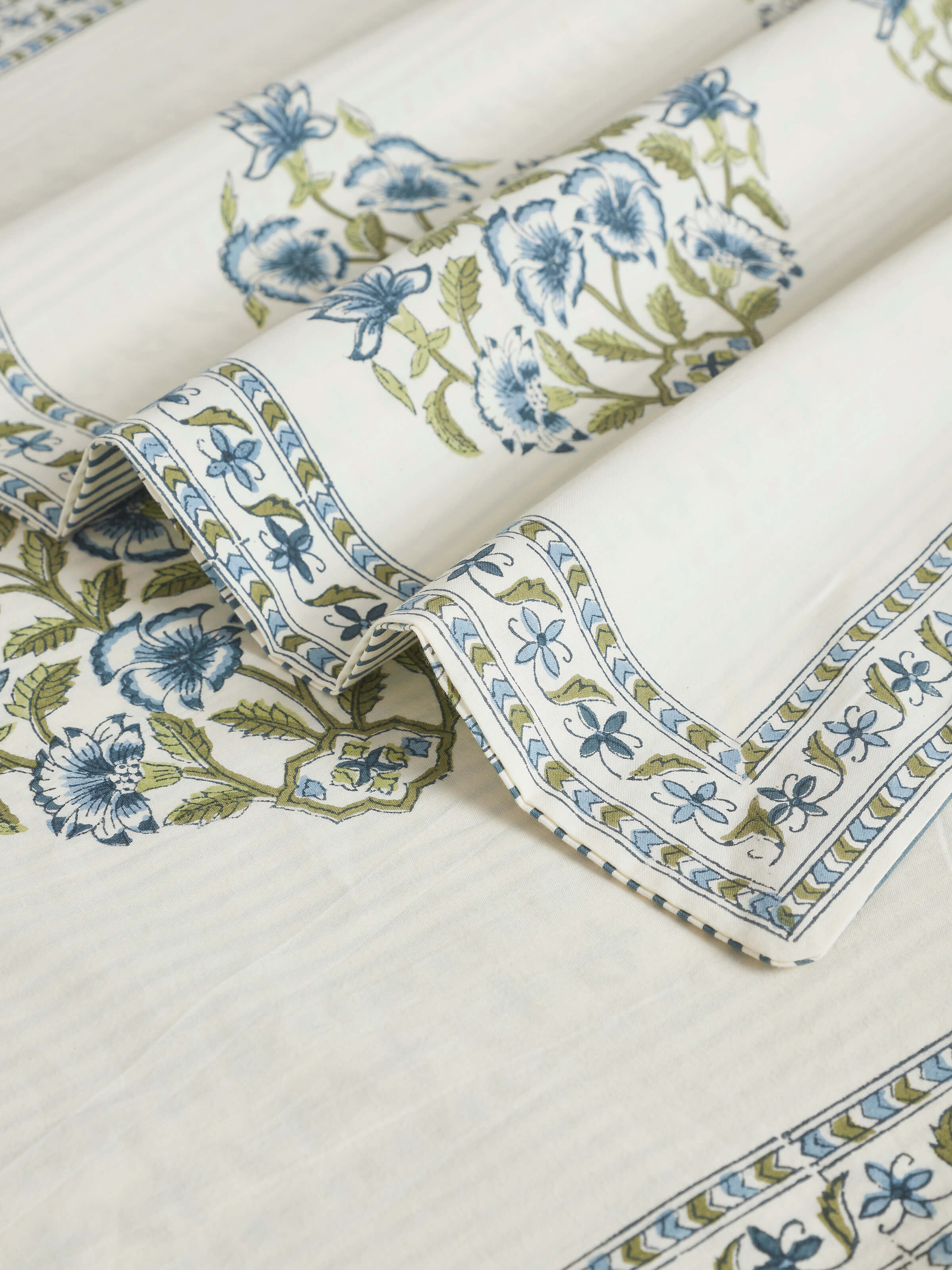 Side view of Aarunya blue buta cotton Sanganeri block printed queen bedsheet set displayed on a bed