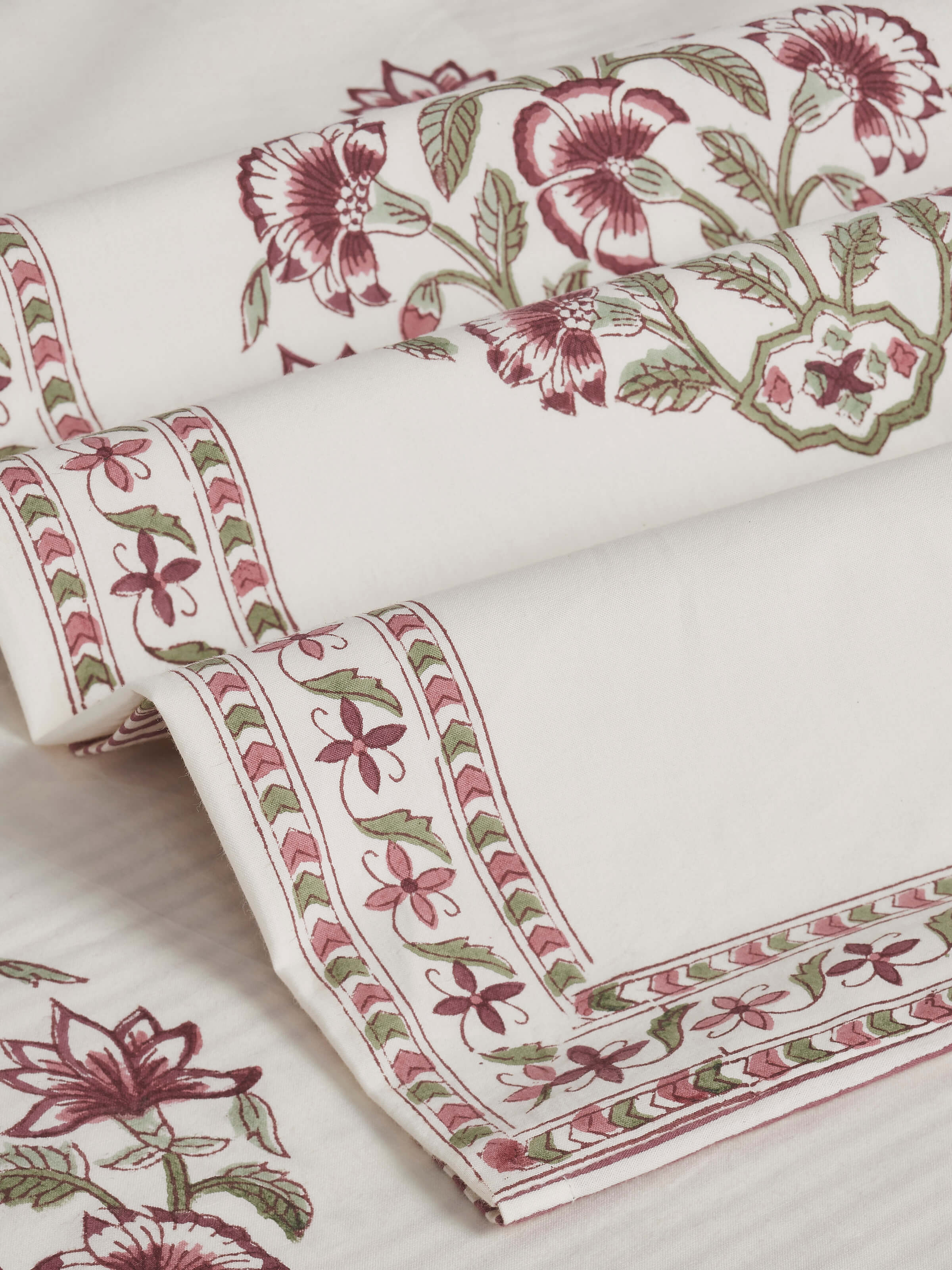 Side view of the Aarunya red buta cotton Sanganeri block printed queen bedsheet set, focusing on the fabric texture.
