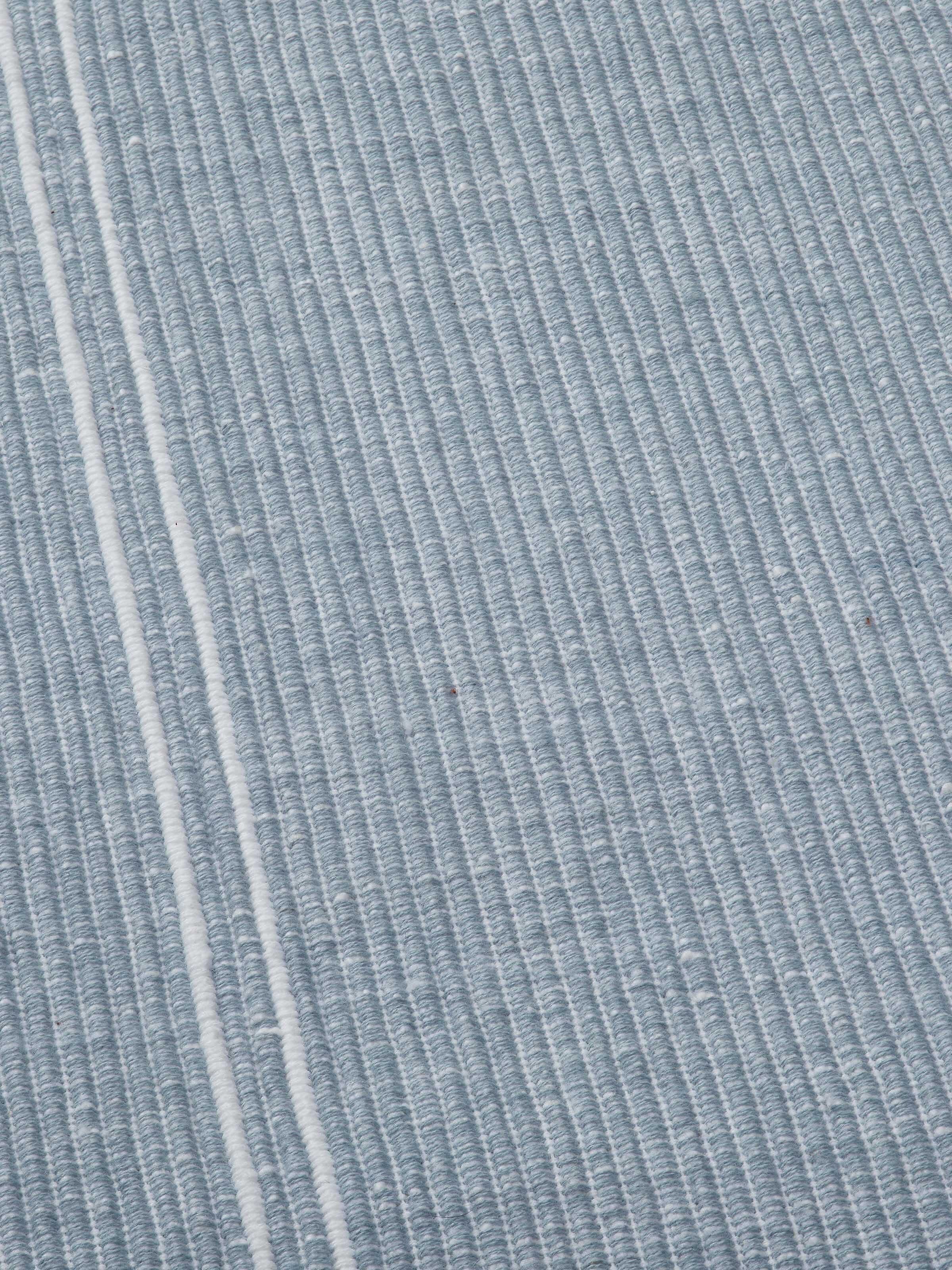 Detail shot 2: Detailed view of hemmed edge and striped fabric in soft light blue hues.