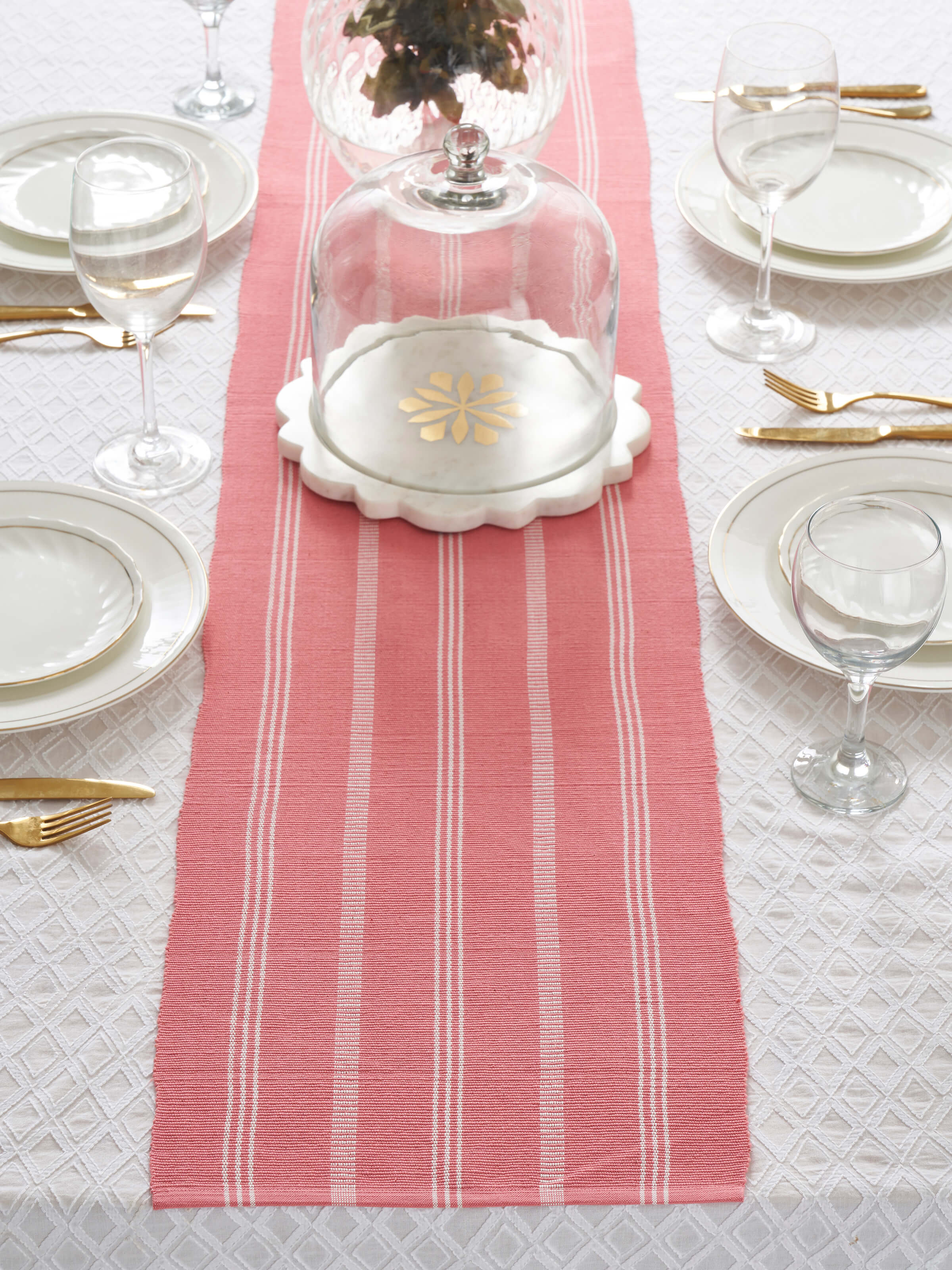 A styled lifestyle image of the Vastav Pink Stripe Cotton Handloom Table Runner arranged on a dining table, highlighting its elegant handloom craftsmanship and traditional Indian design.