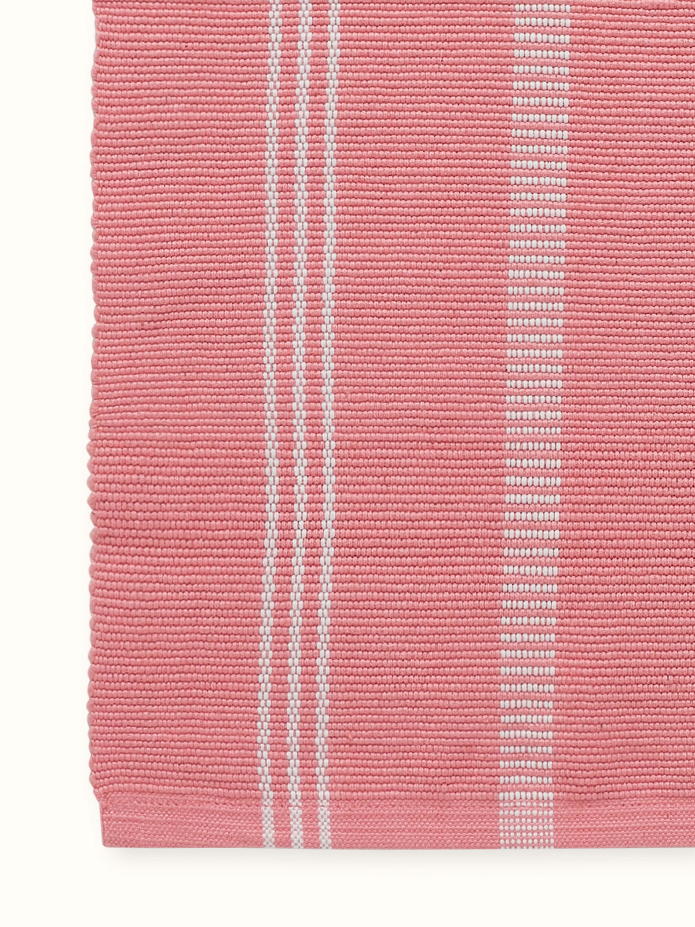 A detailed macro shot of the handwoven fabric texture on the Vastav Pink Stripe Cotton Handloom Table Runner, emphasizing the artisanal quality and natural cotton fibers.