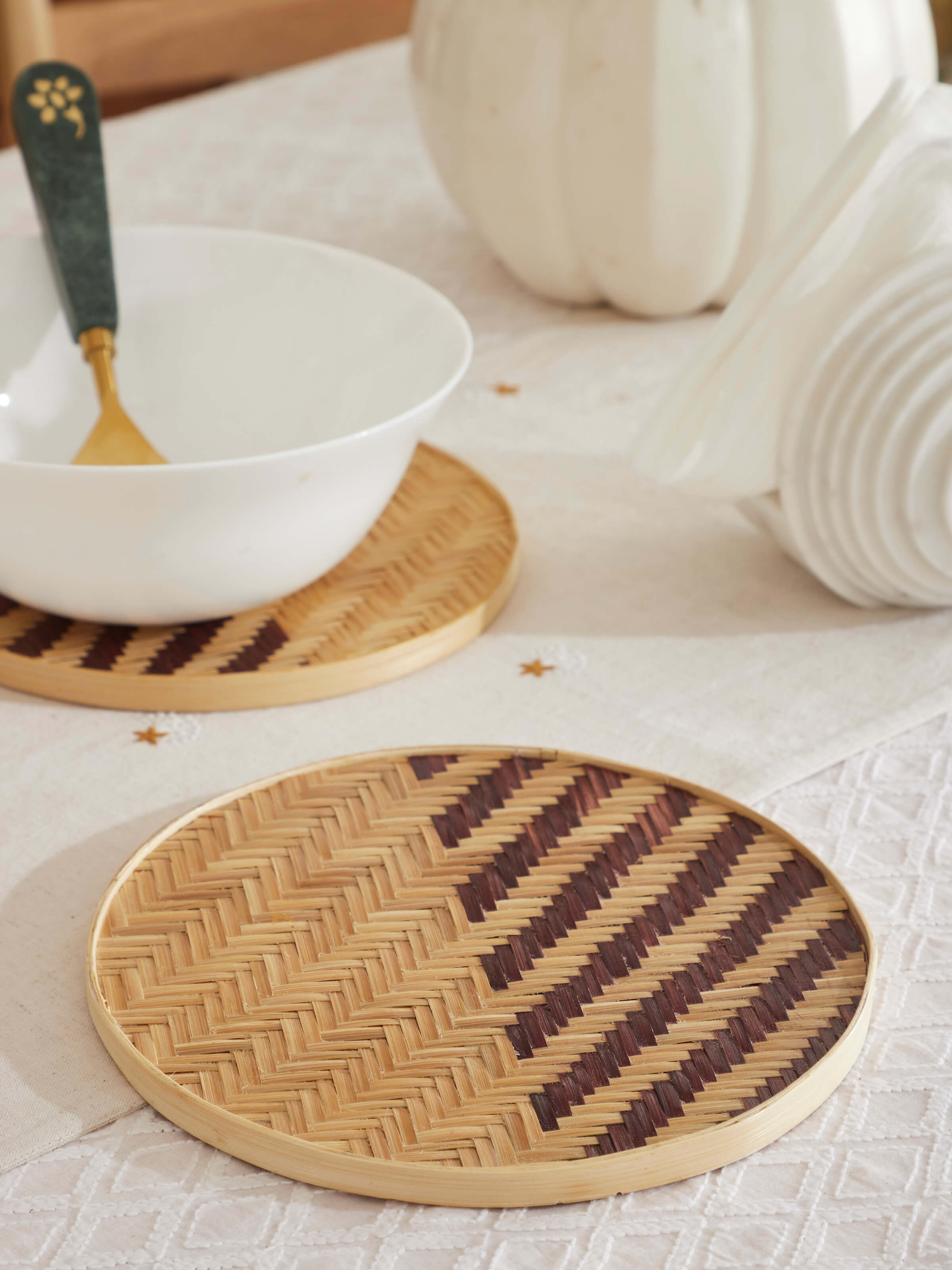 Close-up view of Naveena brown geometric round natural fibre trivet, highlighting its intricate geometric pattern
