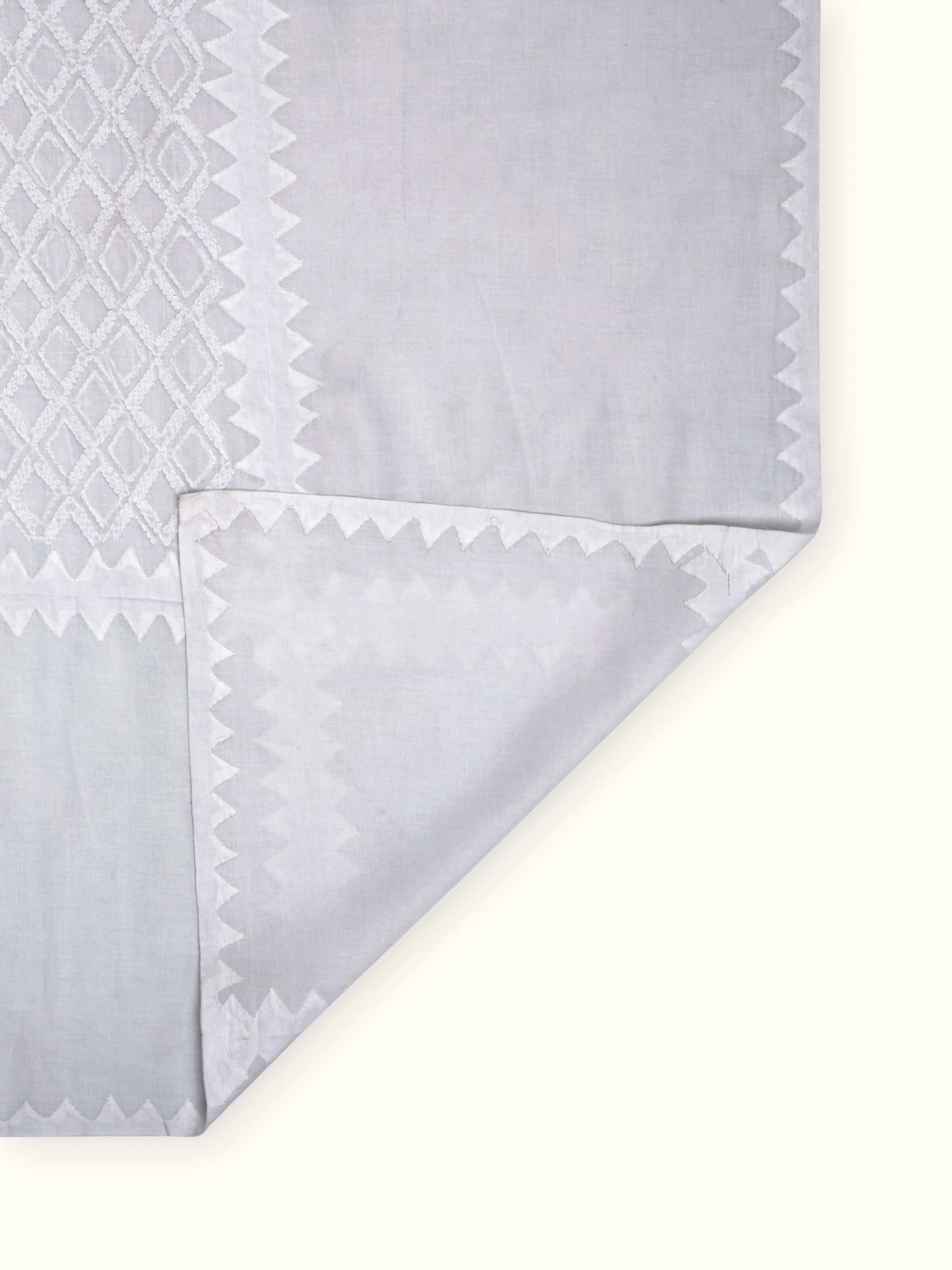 Detailed view of Ananda white geometric cotton Chikankari table cover (4 seater) focusing on the Chikankari embroidery and geometric pattern.