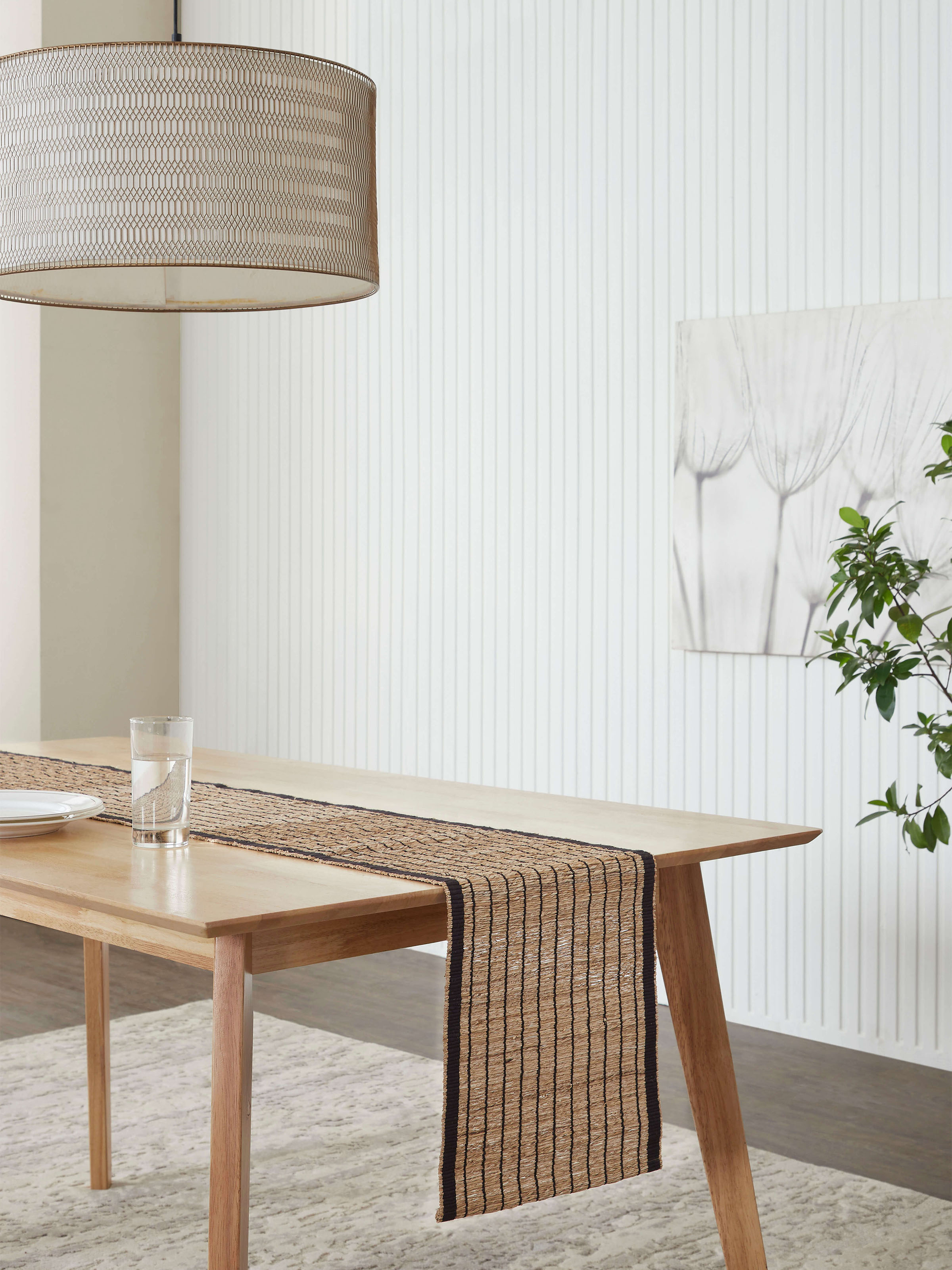 Dining table styled with Nitara black-striped runner in an earthy setting.