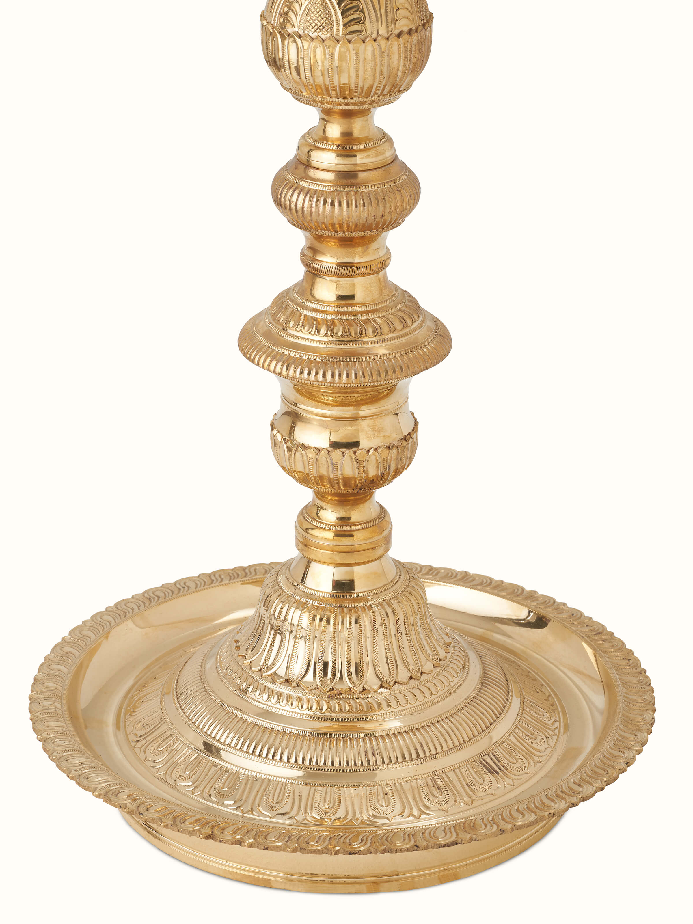 Close-up of polished brass Vilakku stand diya with elegant design features