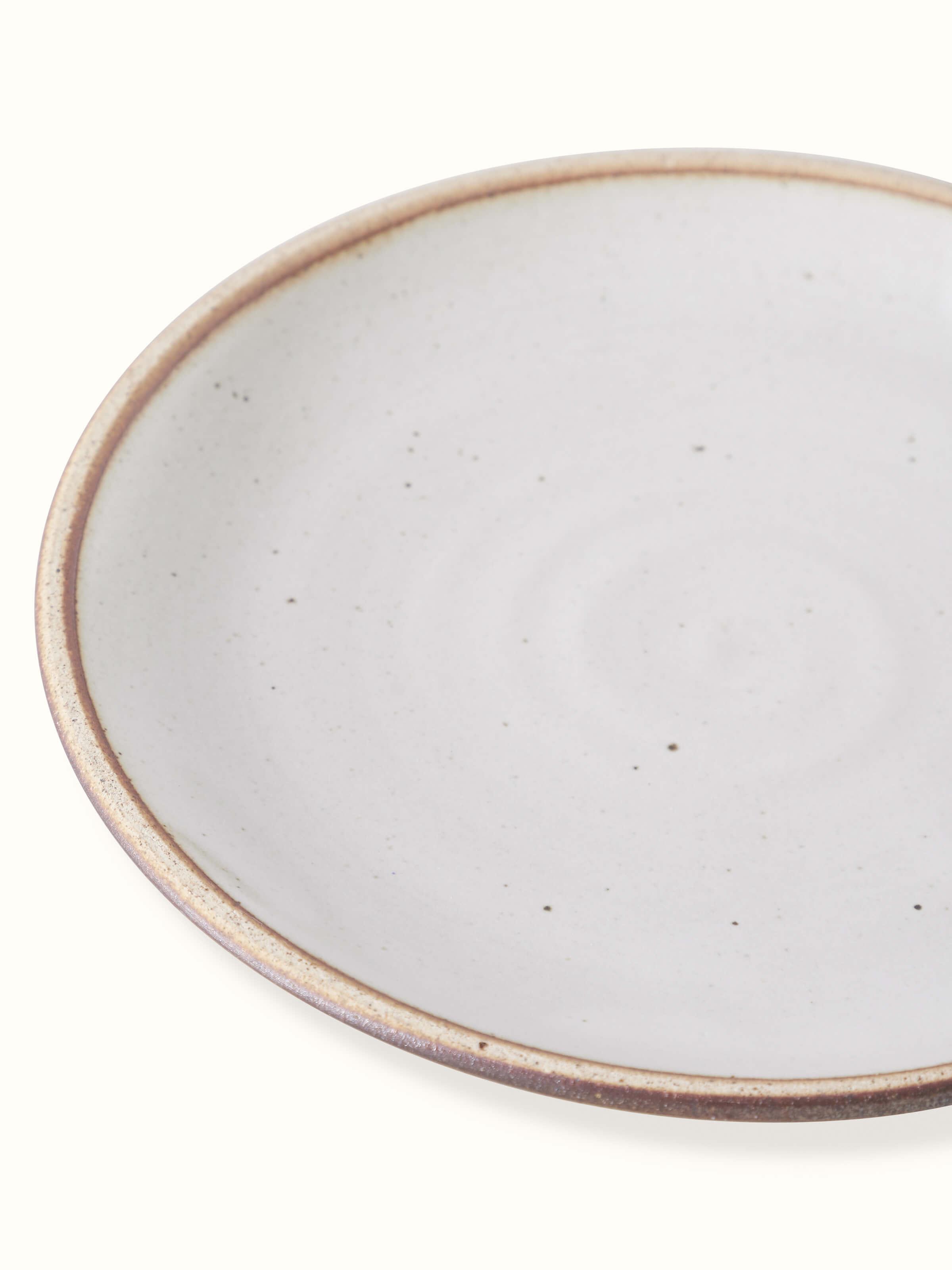 Side view of studio pottery ceramic quarter plate, emphasizing its smooth edges and artistic detail.