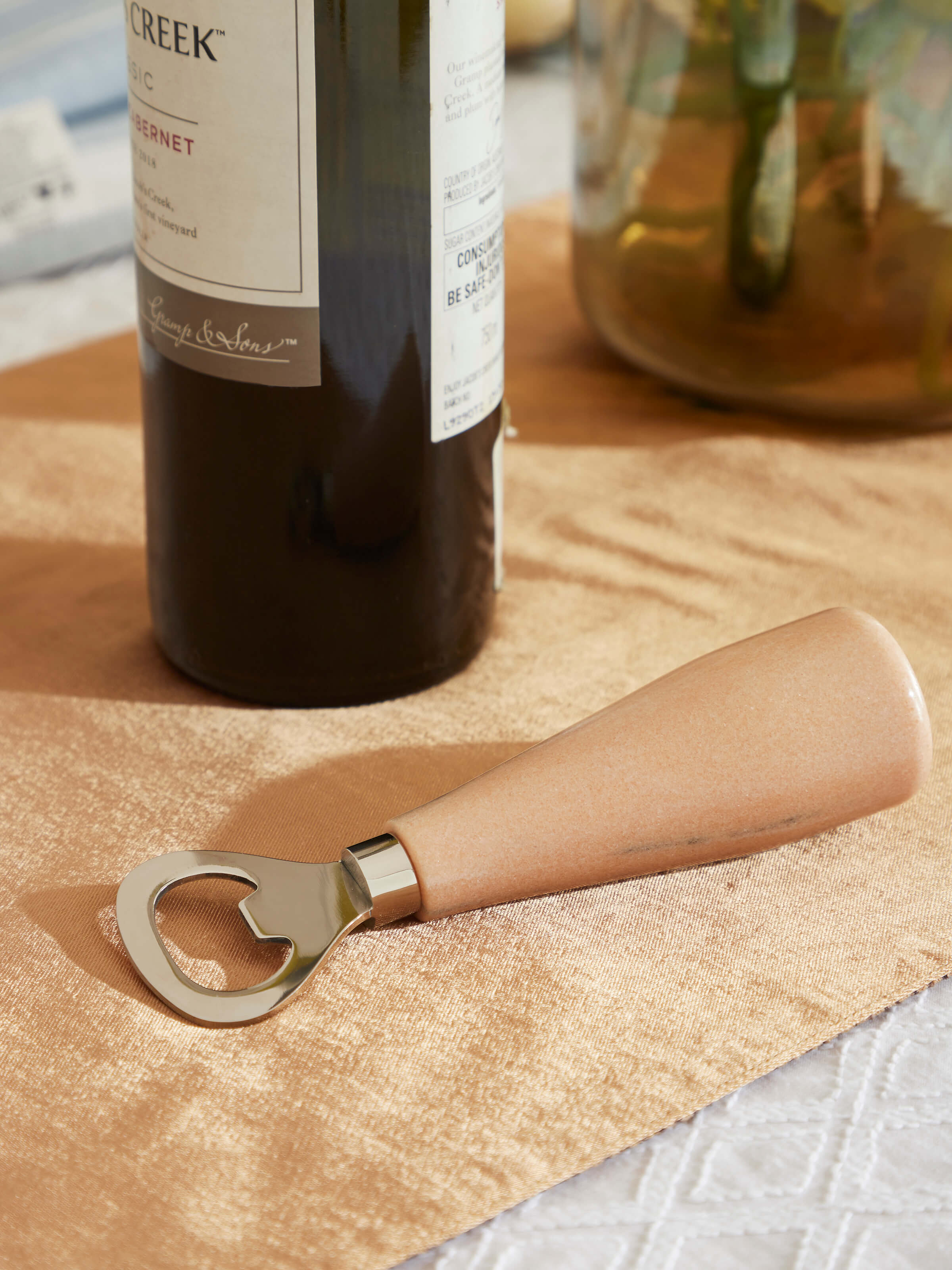 Side view of Marble & stainless steel bottle cap opener in brown, emphasizing its functional design.