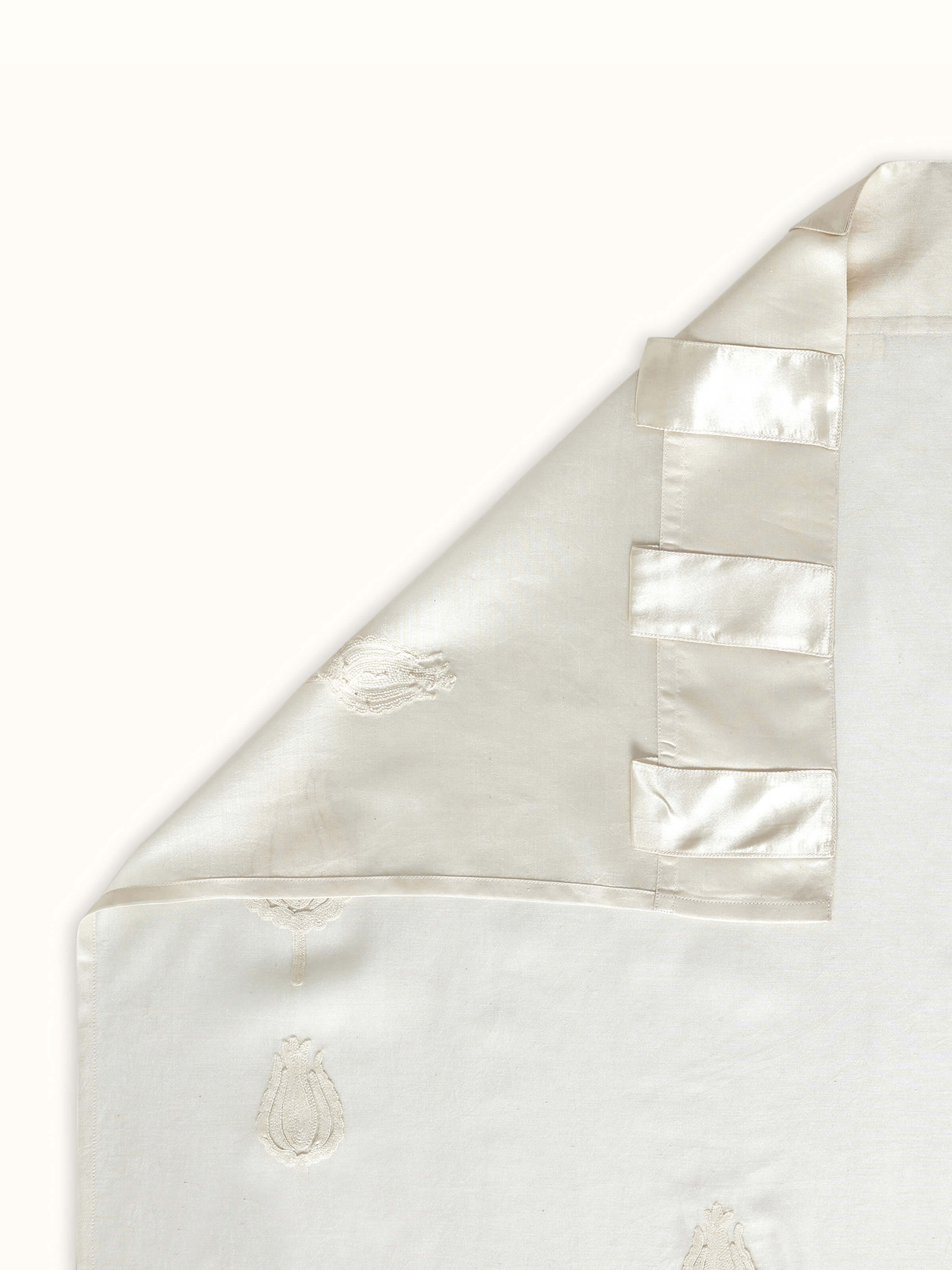 Back view of ivory curtain revealing neat reverse of hand embroidery and sheer drape.