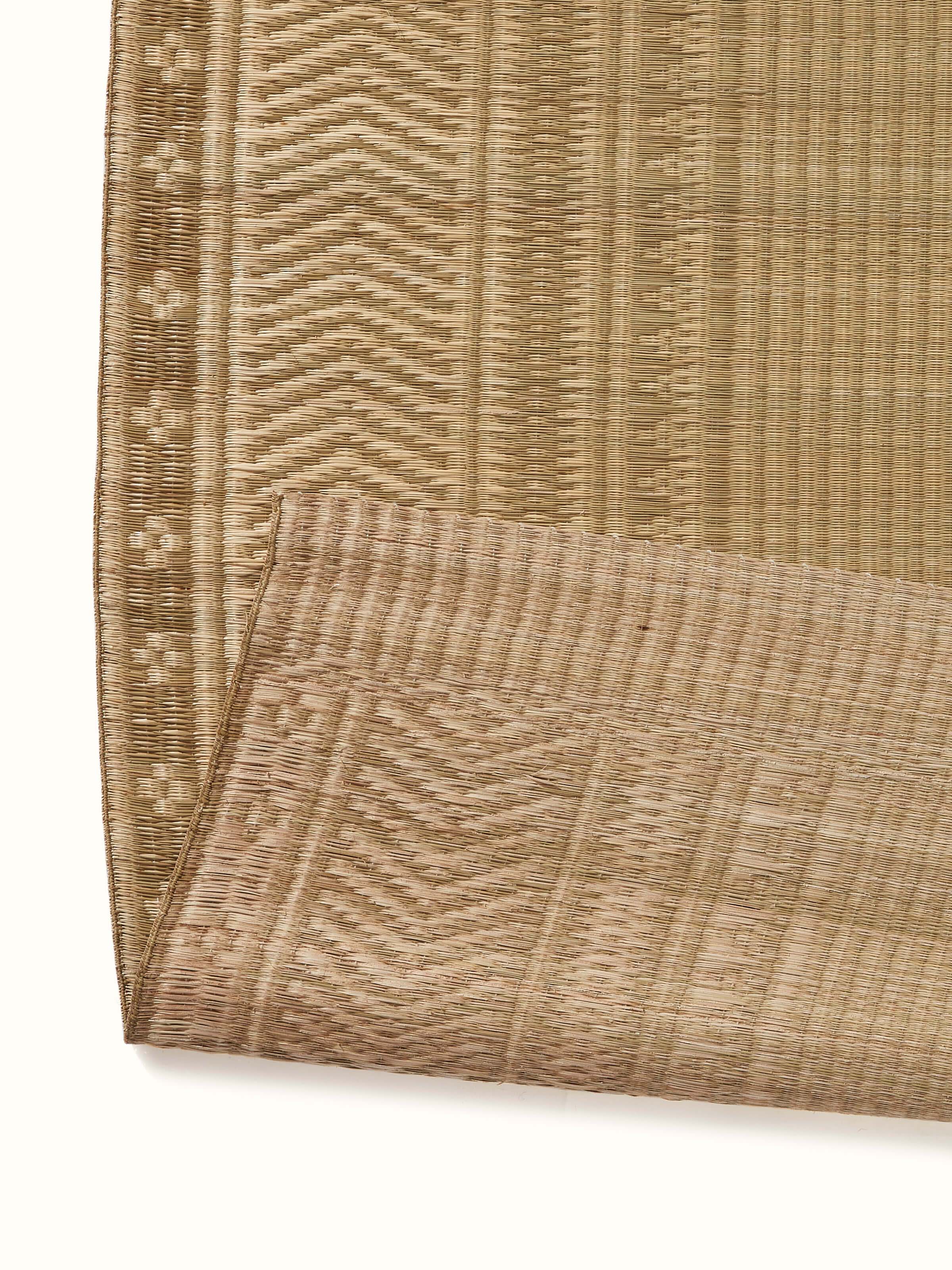 View of Folk geo beige West Bengal madurkathi natural fibre mat in a room setting showing its versatility and decor style.