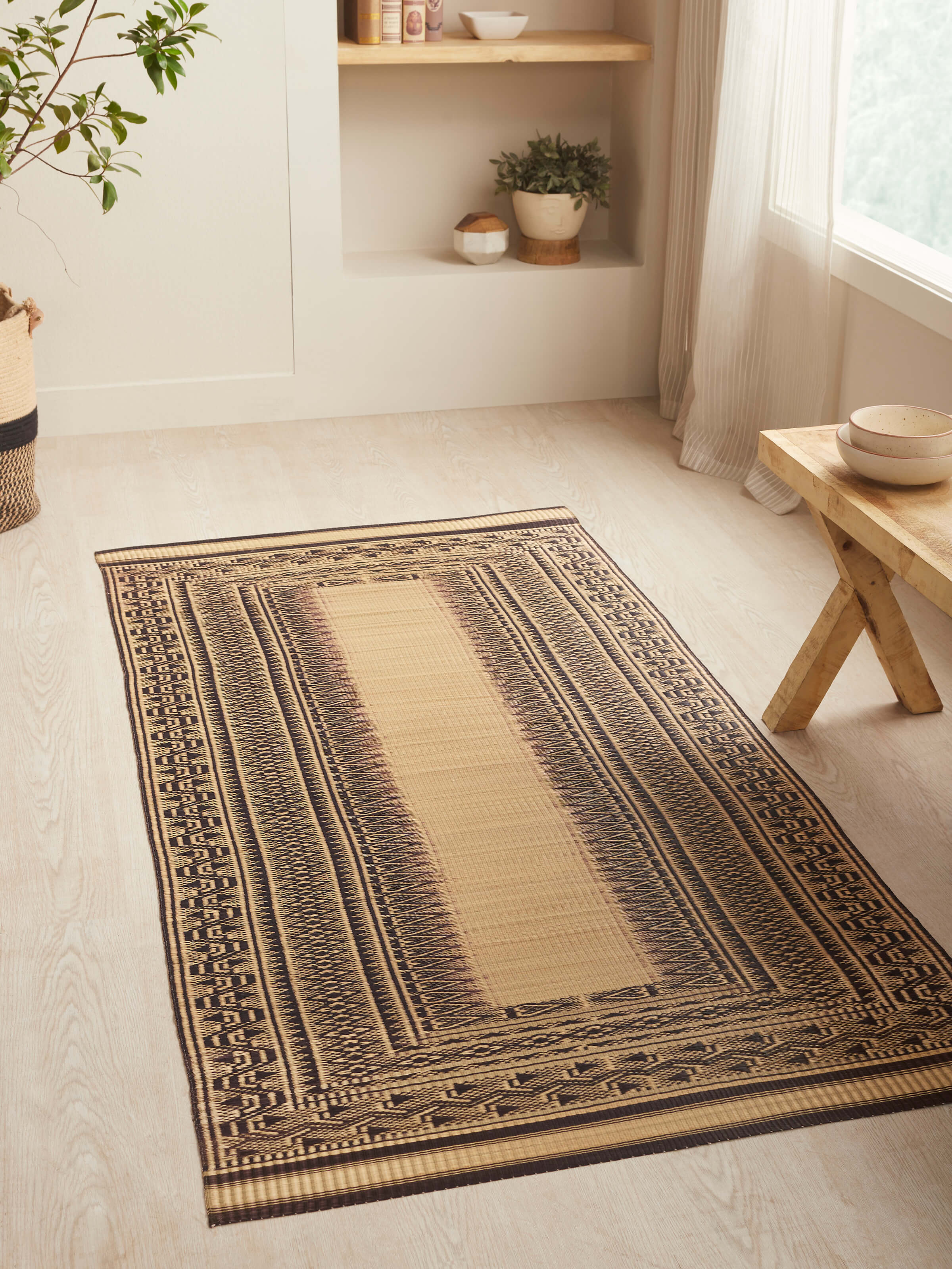 Lifestyle shot of Folk Geo Black West Bengal Madurkathi Natural Fibre Mat enhancing a room's decor with its unique design.