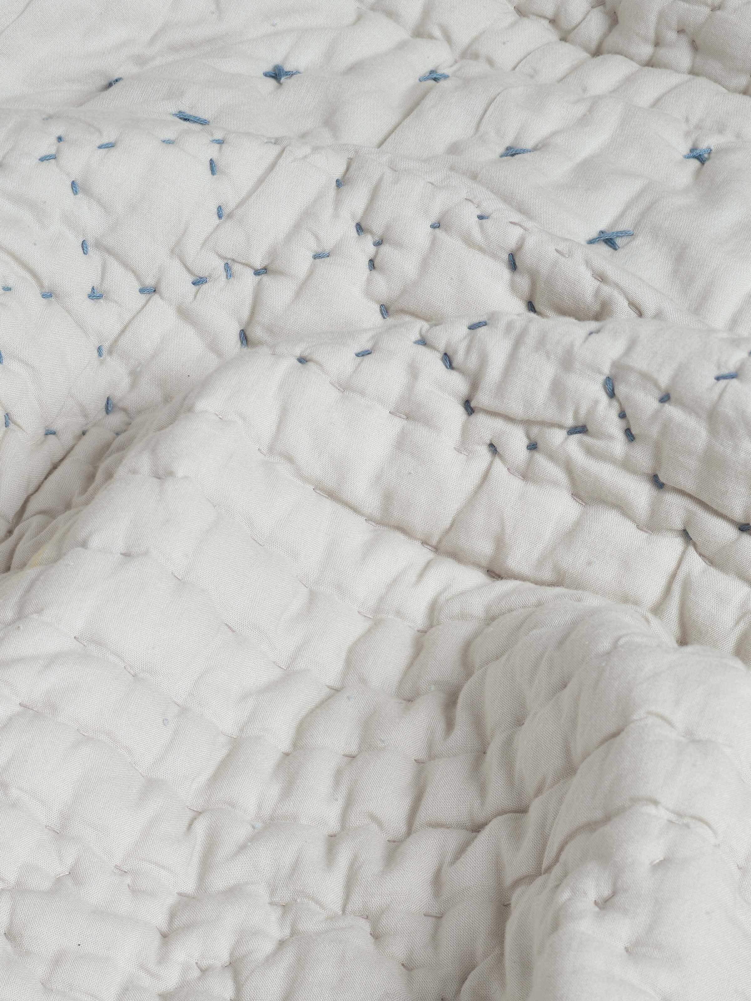 Nitya Blue Textured Stripe Cotton Razai Embroidered Double Bedspread Set folded, emphasizing the embroidery and texture.