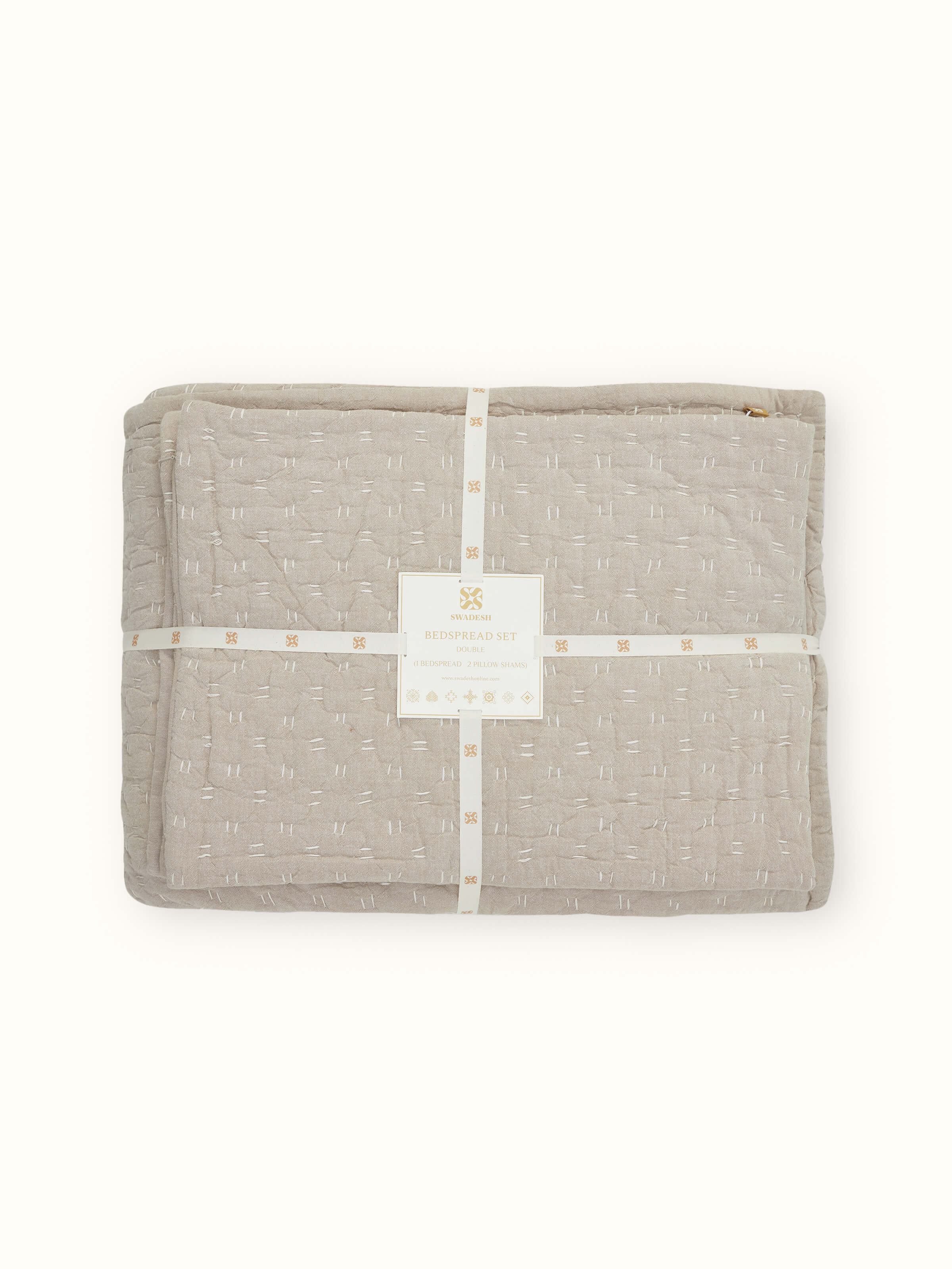 Lifestyle shot of Vaayu beige chambray textured cotton razai embroidered double bedspread set in a bed setting