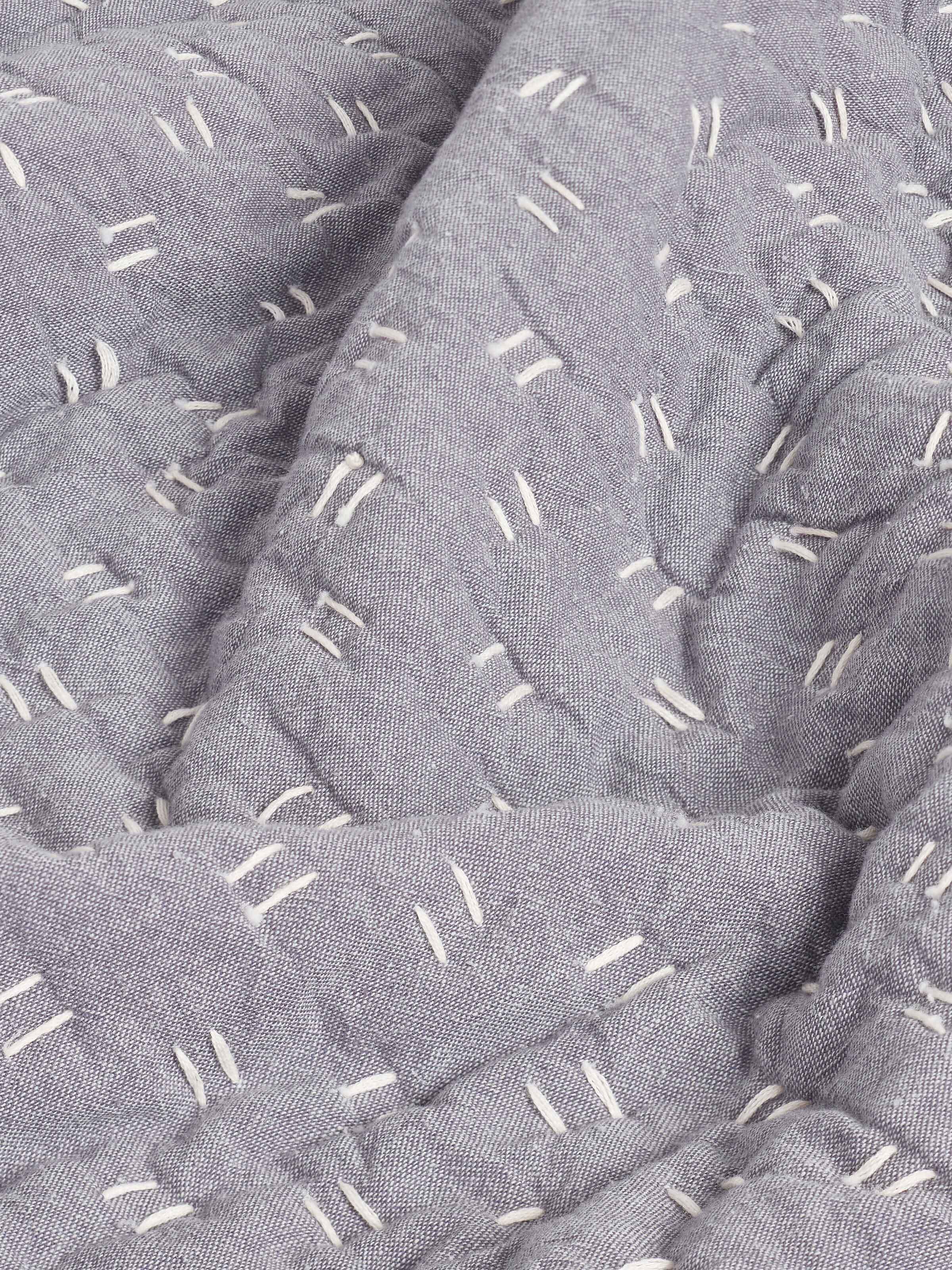 Angled view of Vaayu Grey Chambray Textured Cotton Razai Embroidered Double Bedspread Set (3 pcs), highlighting the embroidered details.