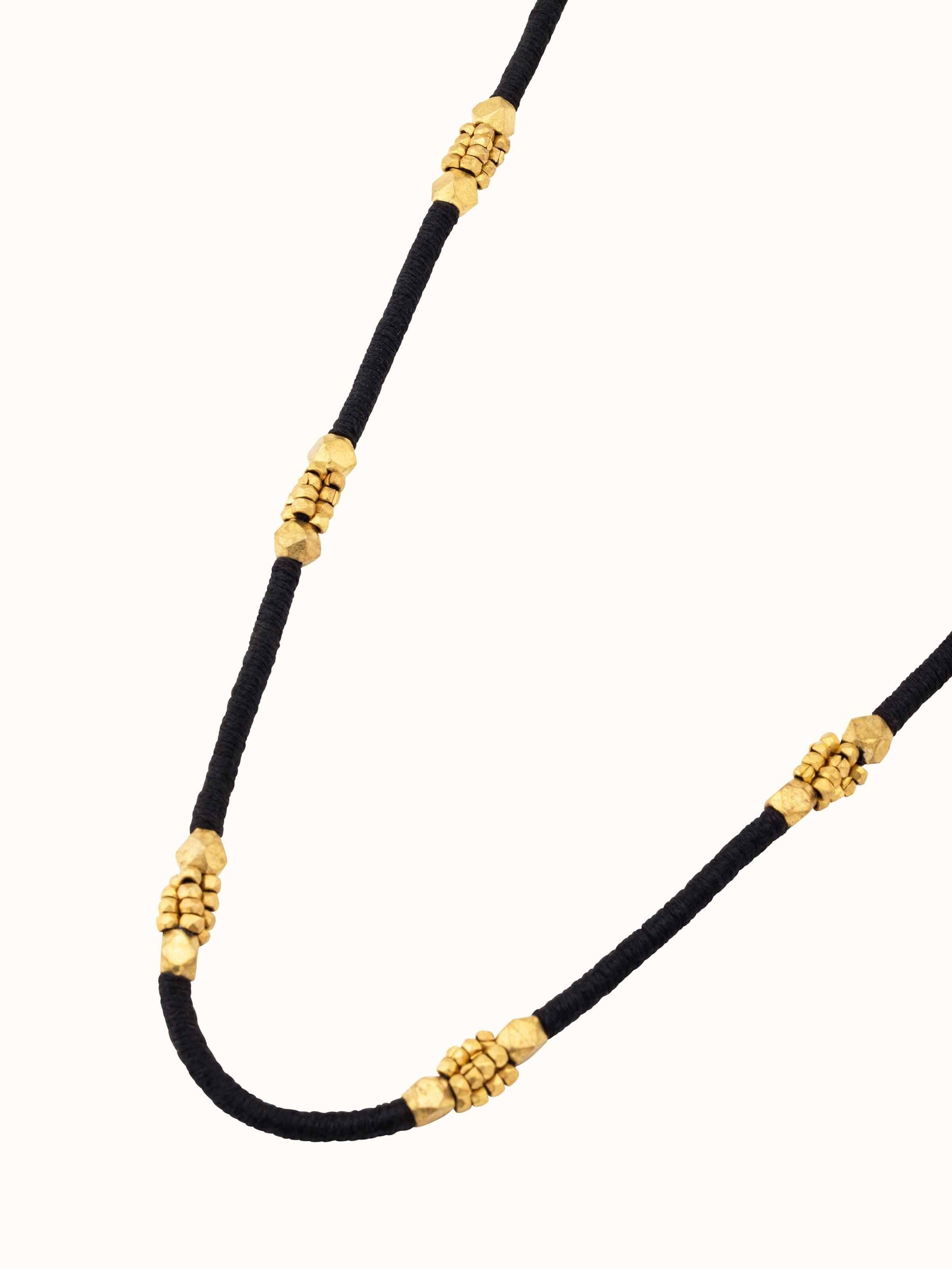 Overhead view of Dhokra Long Necklace displaying intricate design patterns