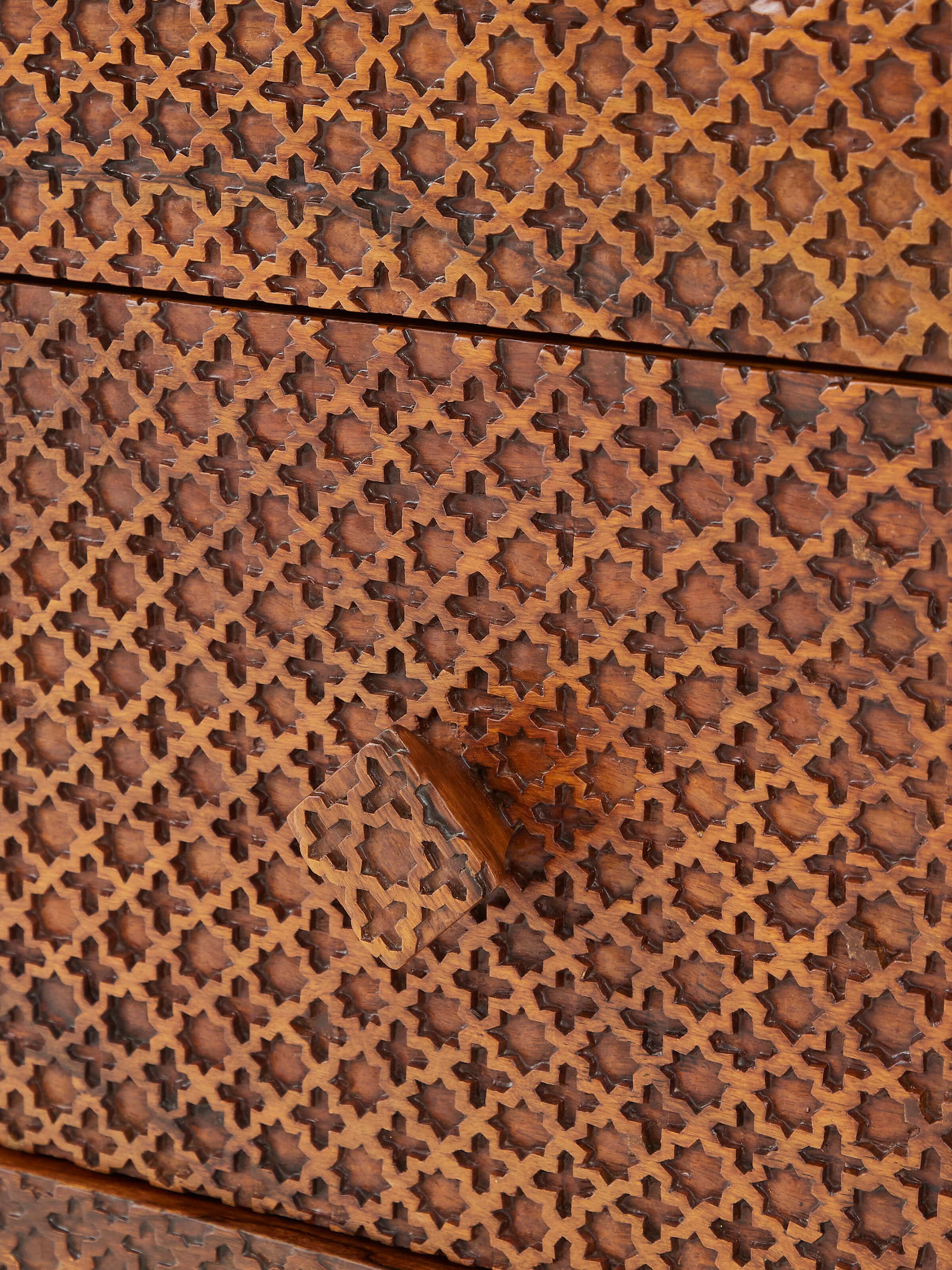 Detailed view of the carved patterns on the dressing table's drawer and sides