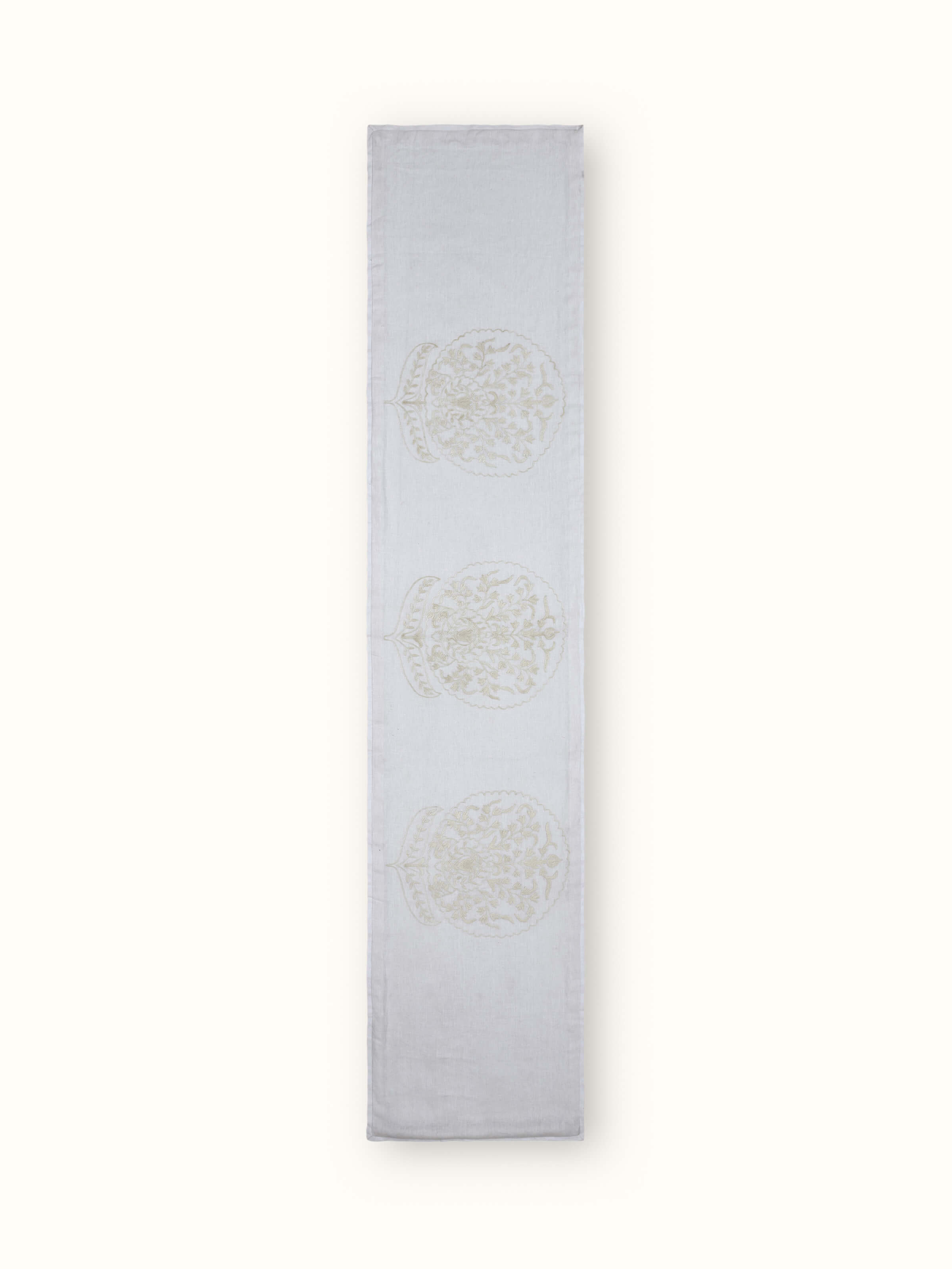 Front view of white linen bed runner with carnation buta motifs and crewel hand embroidery.