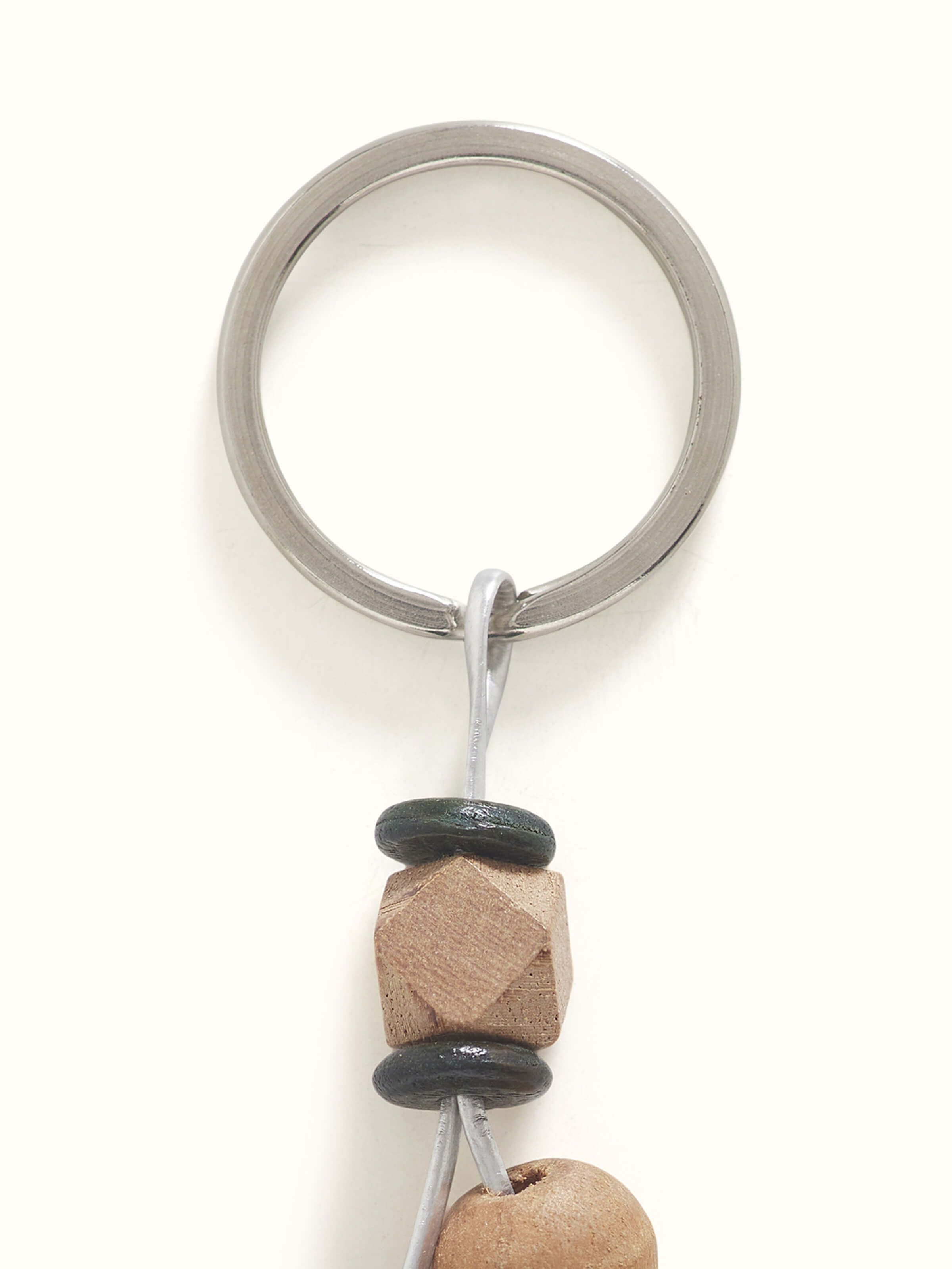 Side view of brown block-making wooden keychain, showing its shape and details.