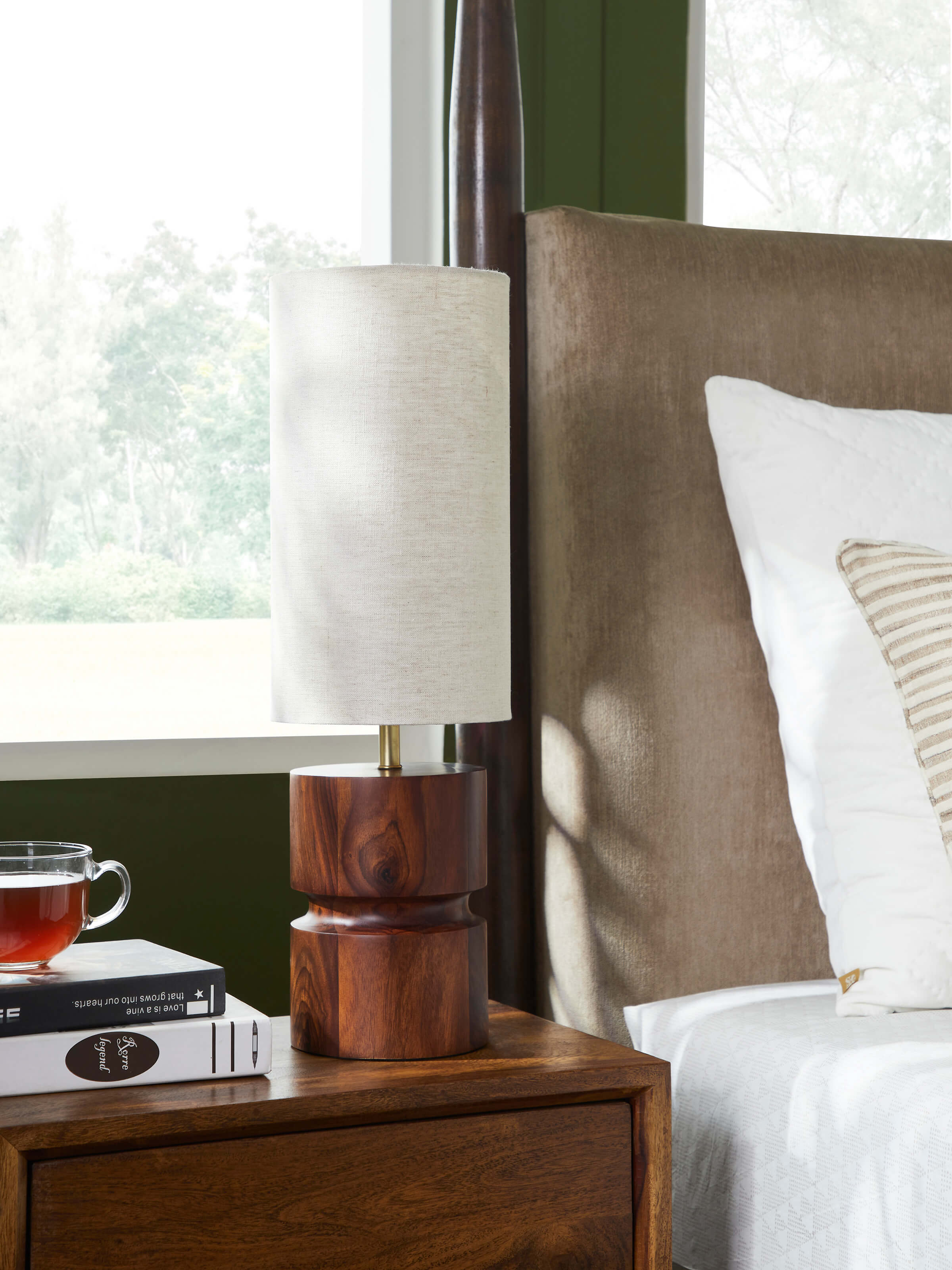 Close-up of tall beige wood and cotton fabric table lamp, highlighting the fabric texture and wooden base.