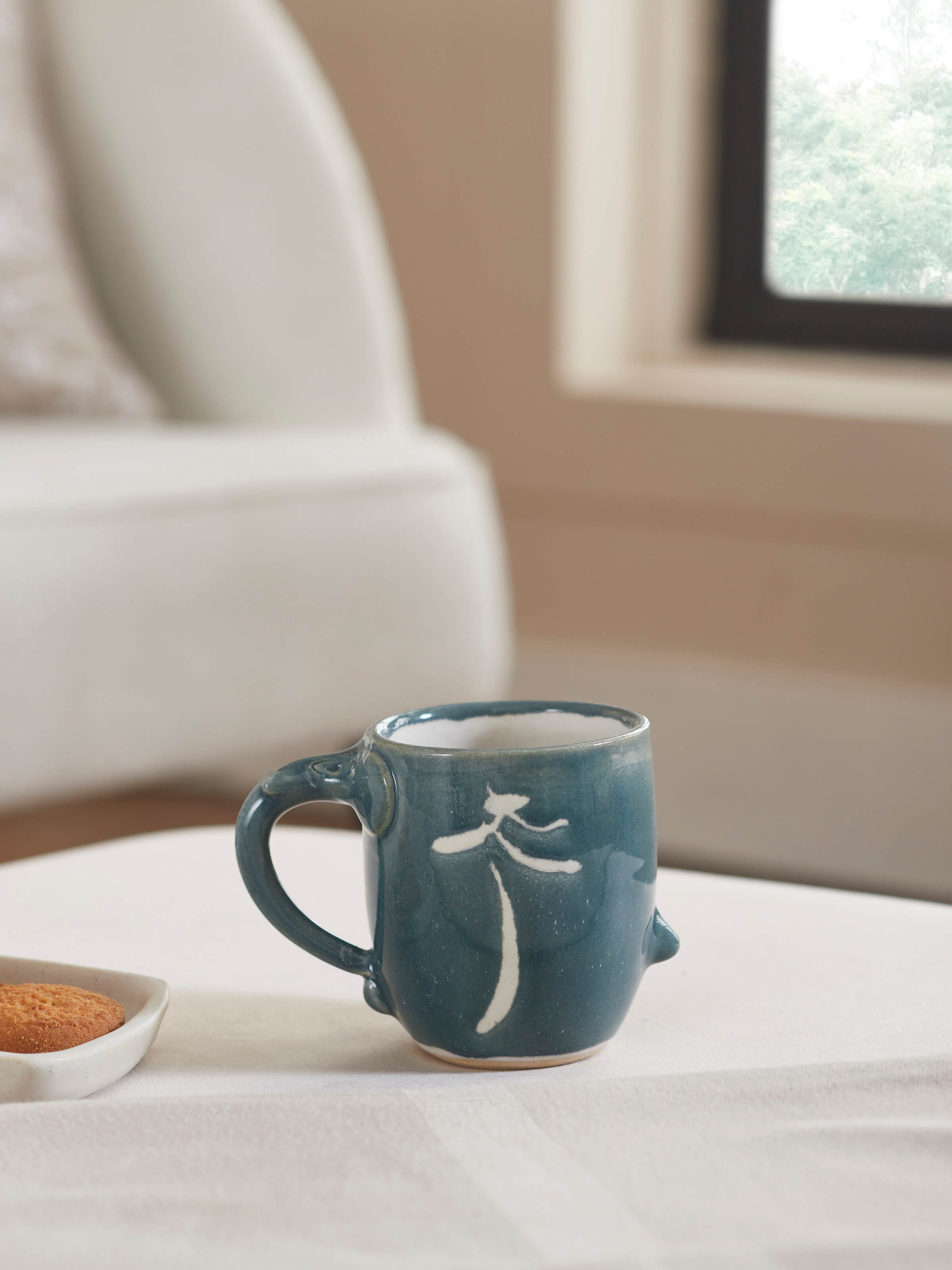 Close-up view of the studio pottery ceramic coffee mug in blue, highlighting the texture and finish.