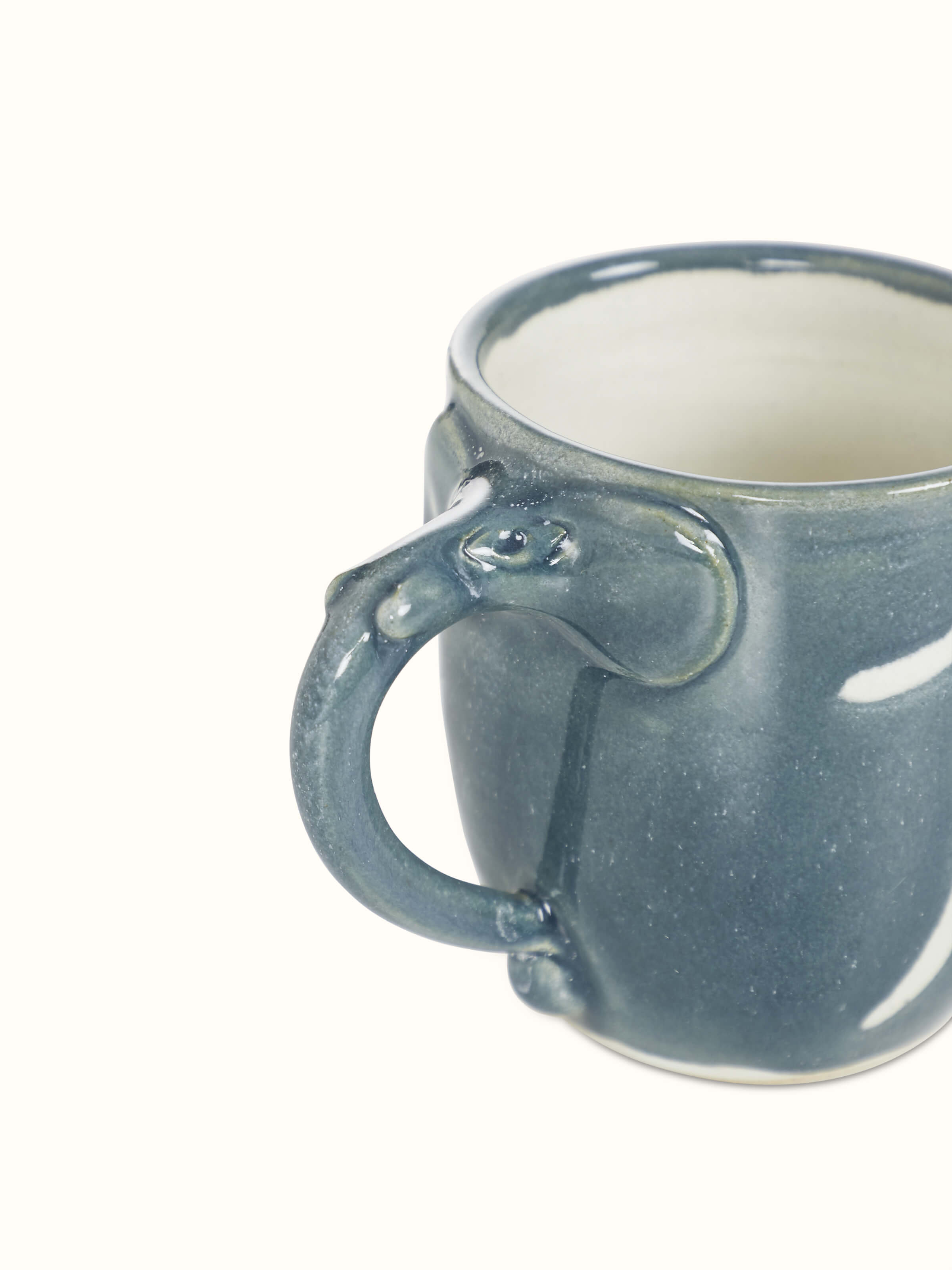 Side view of the studio pottery ceramic coffee mug in blue, showing its handle and overall form.